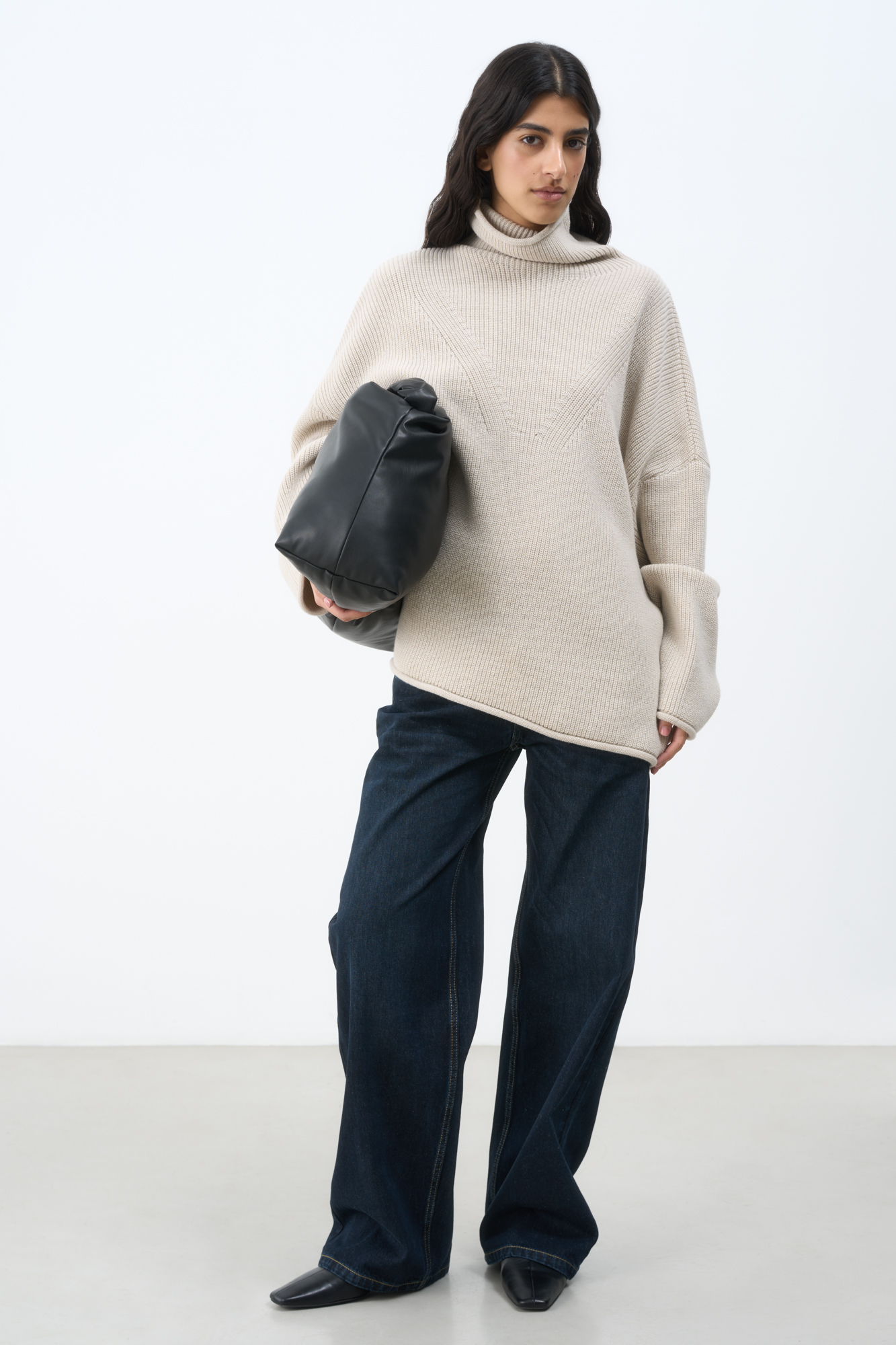 Трикотажный джемпер с высоким воротом. Модель свободного силуэта со спущенной линией плеча и декоративными сбавками.