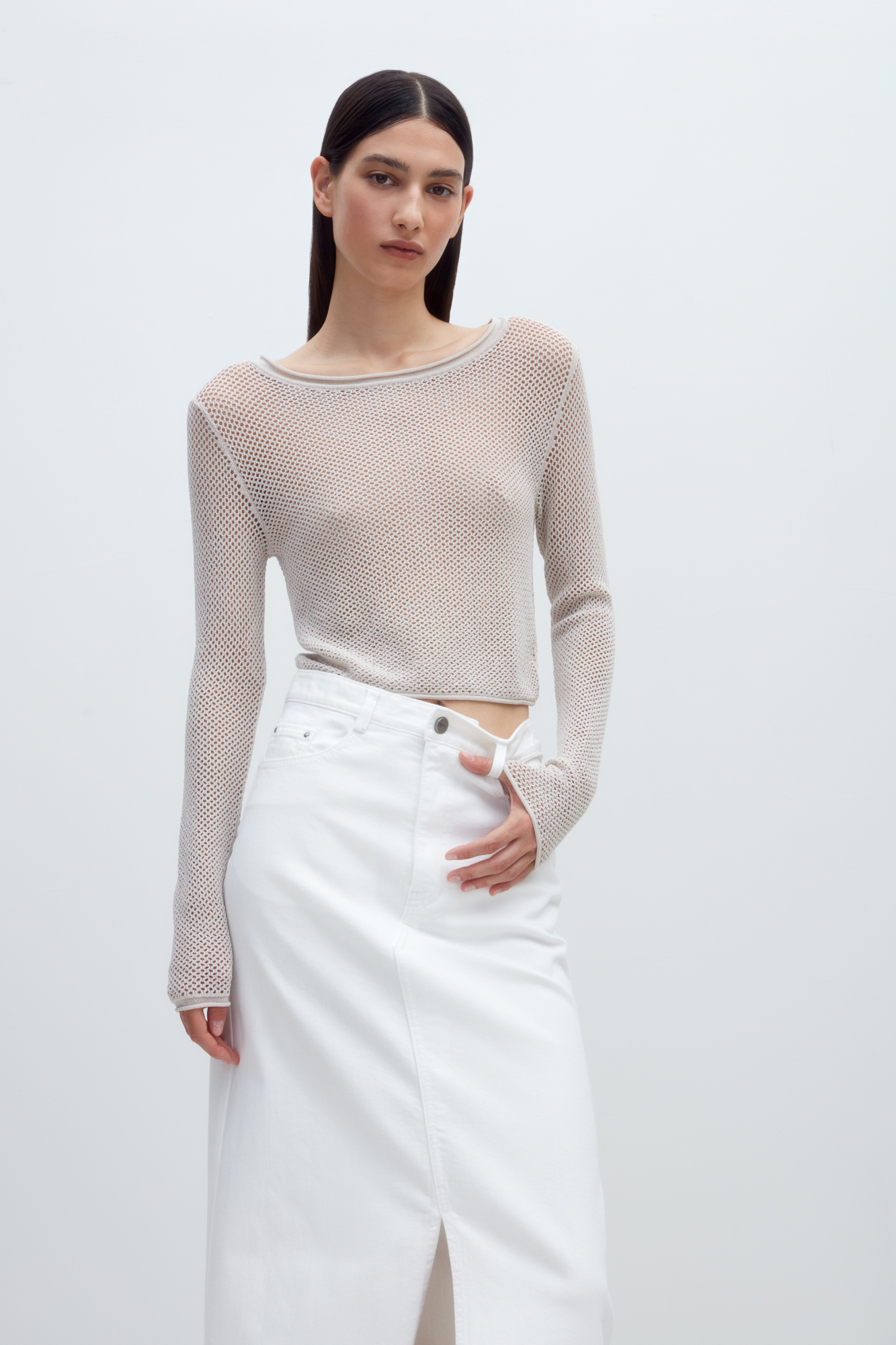 Трикотажный топ из вискозы. Модель прямого силуэта, с длинными рукавами и круглым вырезом горловины. Изделие выполнено ажурной вязкой.