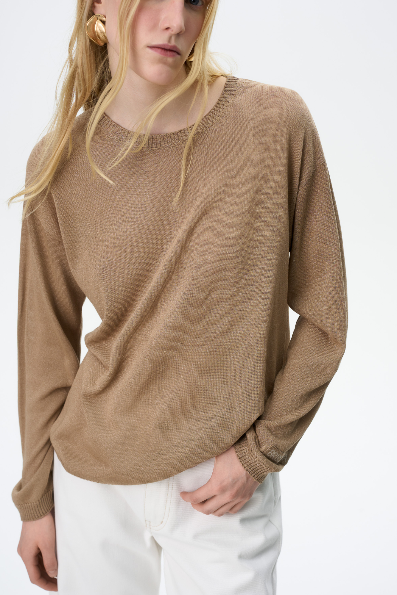 Трикотажный лонгслив из тонкой вискозы свободного силуэта. Спущенная линия плеча, круглый вырез и брендированный ярлык на рукаве.