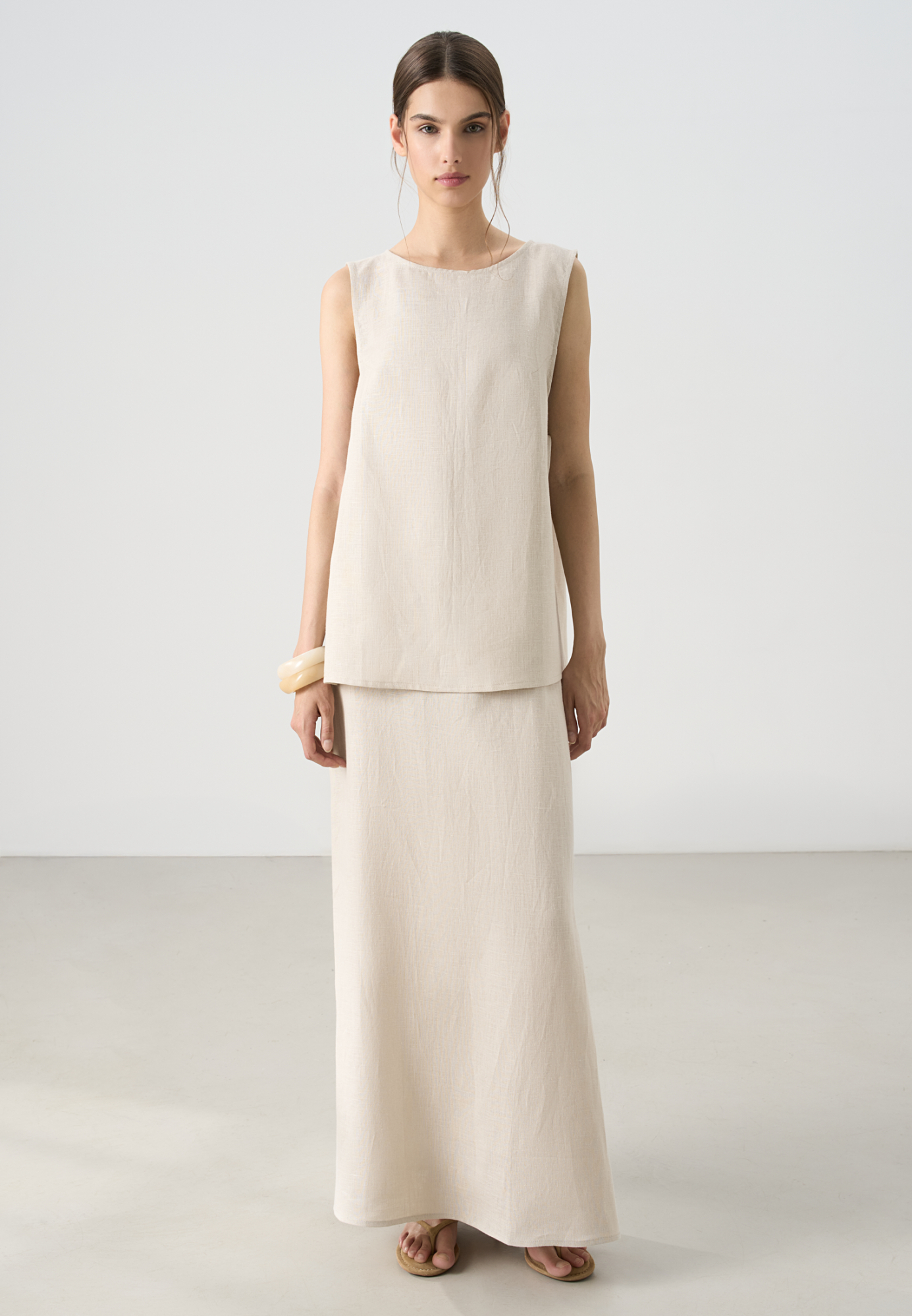 Юбка длины макси из 100% льна. Модель прямого кроя, с небольшим разрезом сбоку, эластичным поясом на резинке и застежкой на молнию.