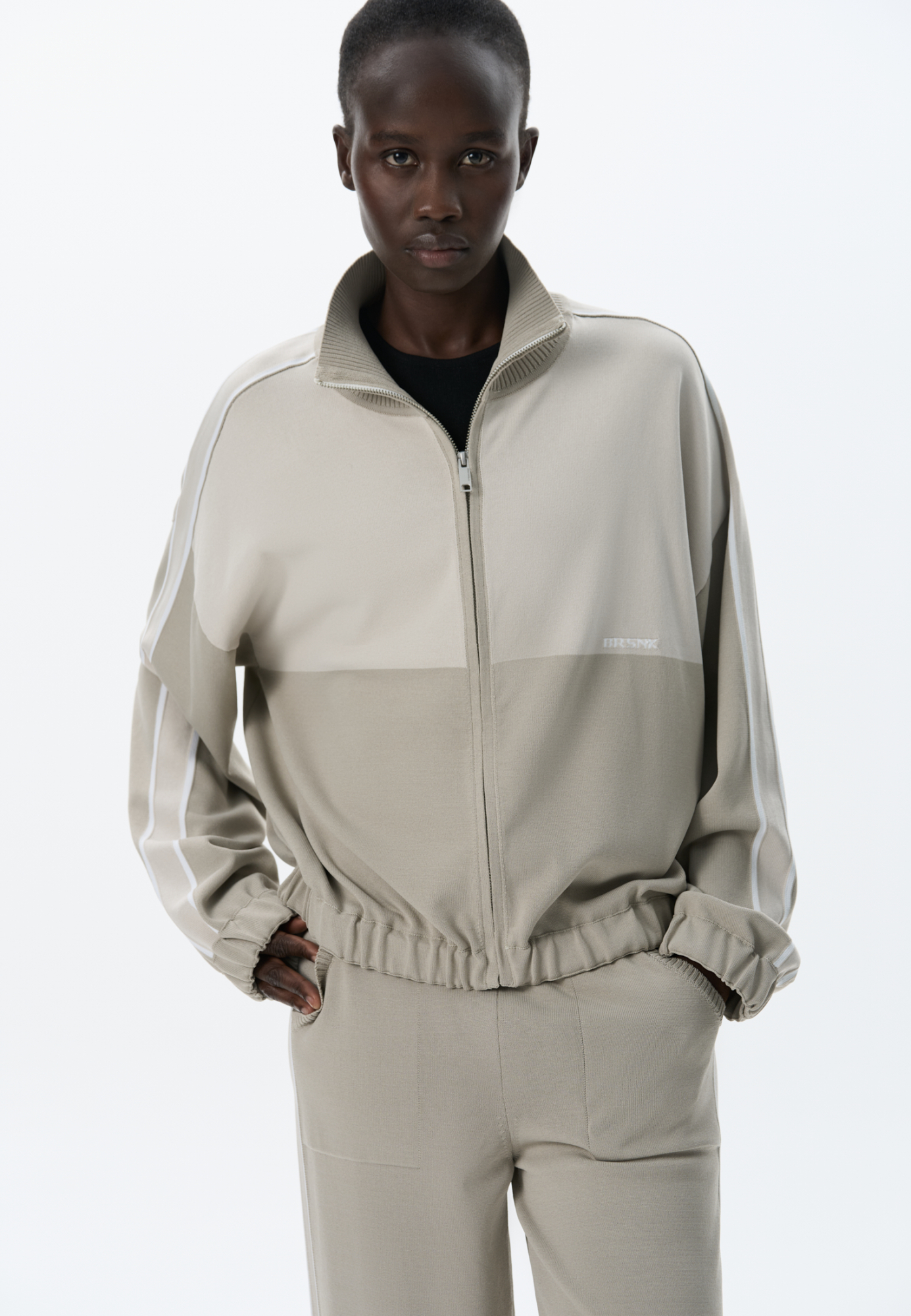 Трикотажный спортивный бомбер из вискозы. Модель прямого силуэта, со спущенной линией плеч, длинными рукавами с широкими лампасами и невысоким воротником-стойкой. Низ изделия и манжеты рукавов выполнены на резинке. Застежка на молнию. Брендированный жаккард на спине.