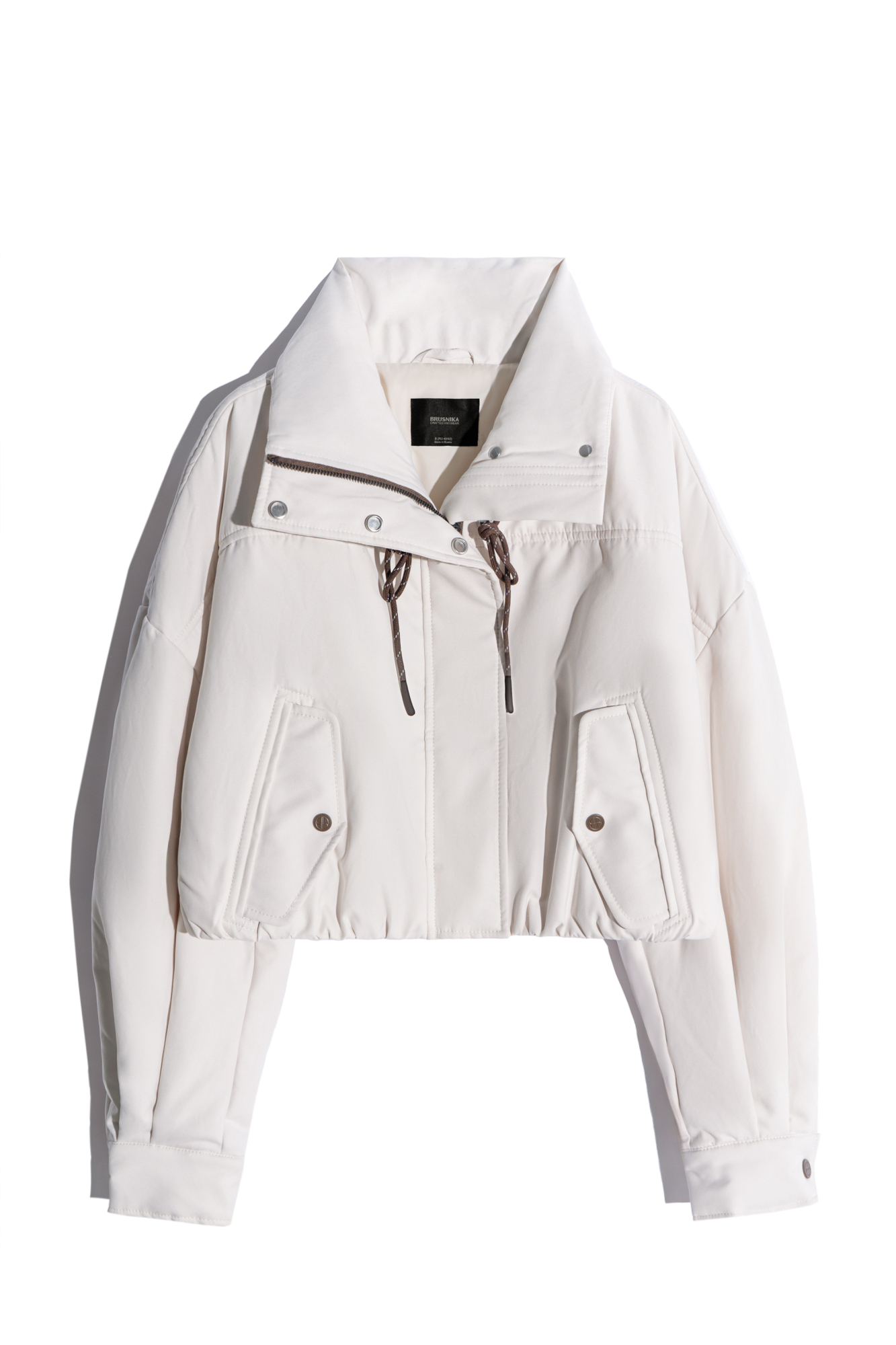 Объемный бомбер с воротником-стойкой. Модель укороченного силуэта со спущенной линией плеч, глубокими врезными карманами и застежкой на молнию под планку с кнопками. Манжеты рукавов декорированы металлическими брендированными кнопками.