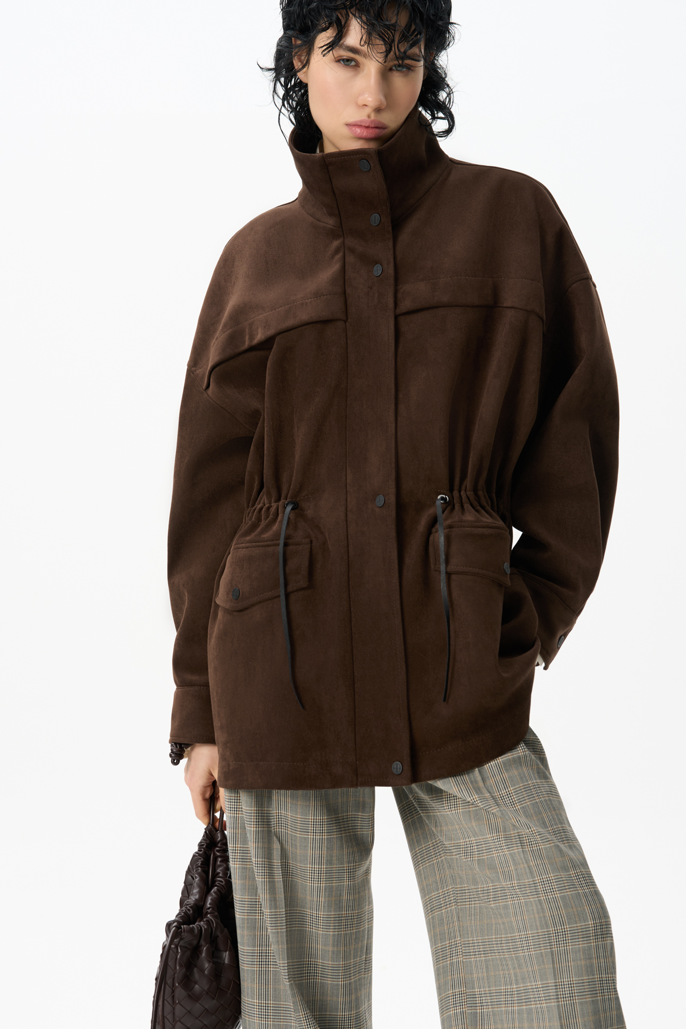 Парка, выполненная из ткани с имитацией внешнего вида и свойств натуральной замши. Модель свободного силуэта с высоким воротником-стойкой, карманами с клапанами и кулиской на талии. Застежка на молнию и магнитные кнопки на планке. Изделие выполнено на подкладке.