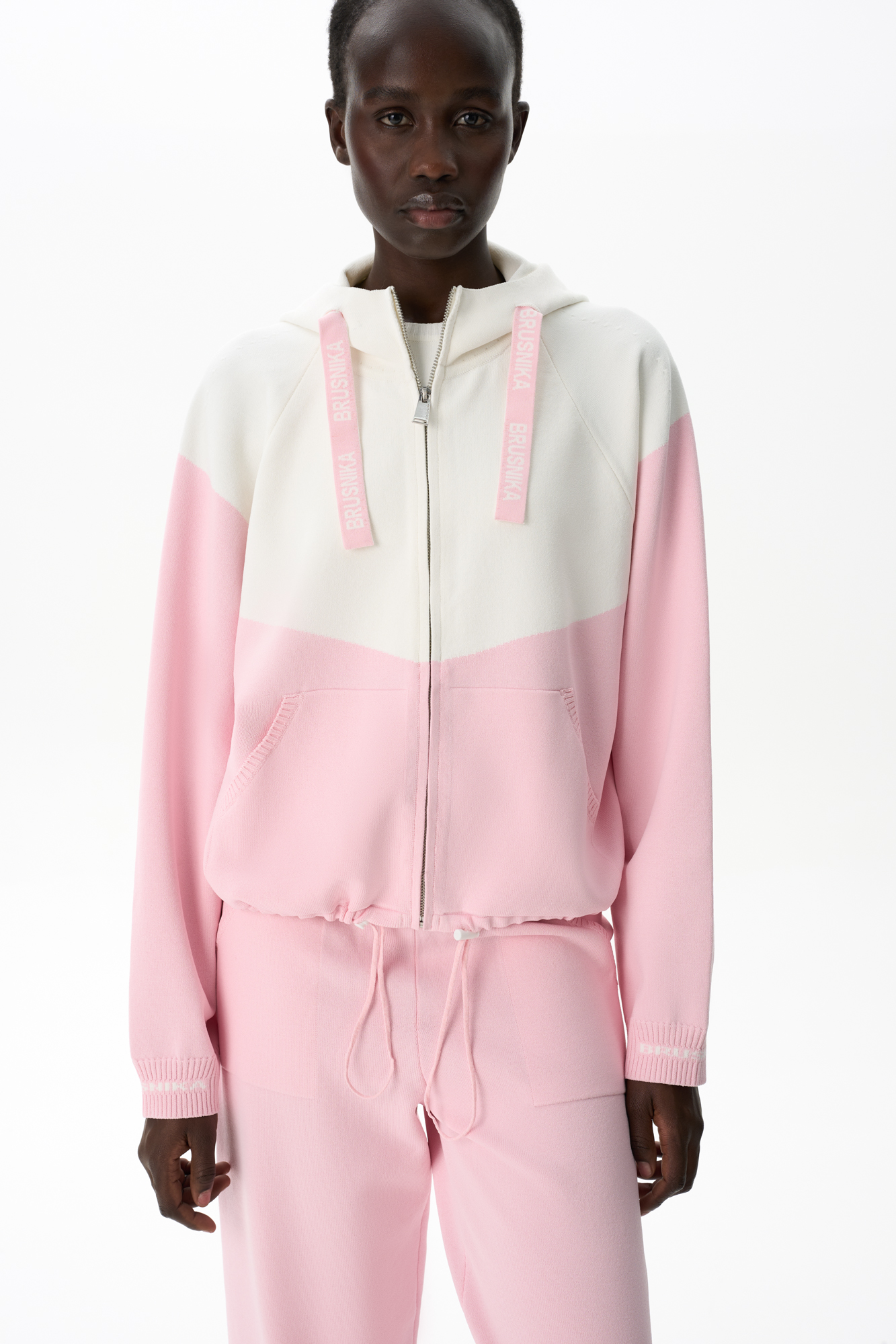 Трикотажный бомбер из вискозы с добавлением эластана. Модель выполнена в спортивном стиле, с капюшоном на шнурке и карманами. Низ изделия регулируется кулиской. Манжеты на резинке. Застежка на молнию.