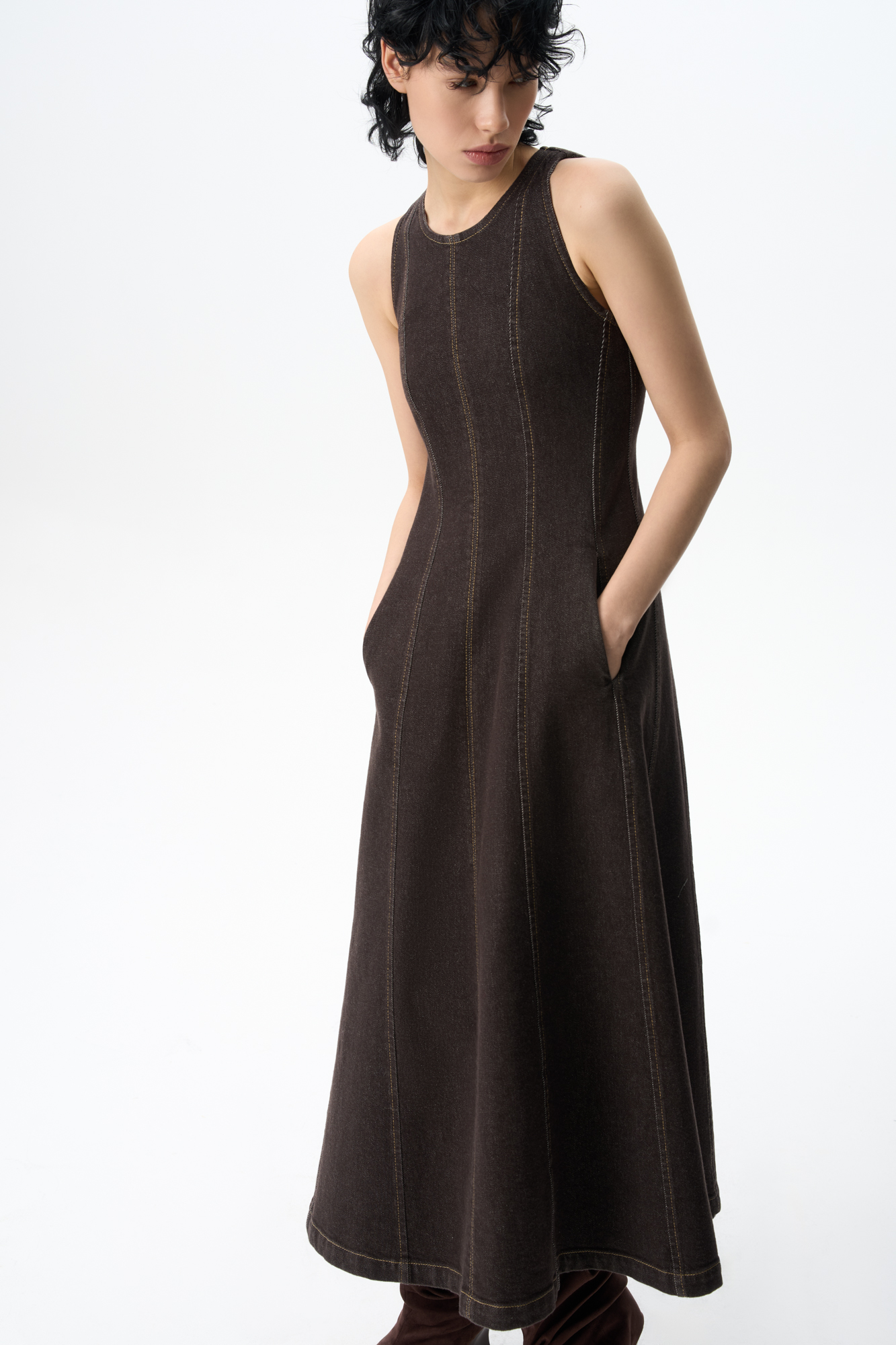 Джинсовое платье длины макси. Модель приталенного силуэта с круглым неглубоким вырезом горловины, без рукавов на широких бретельках, с карманами. Застежка на молнию на спинке. Изделие декорировано вертикальными швами и строчкой контрастного цвета.