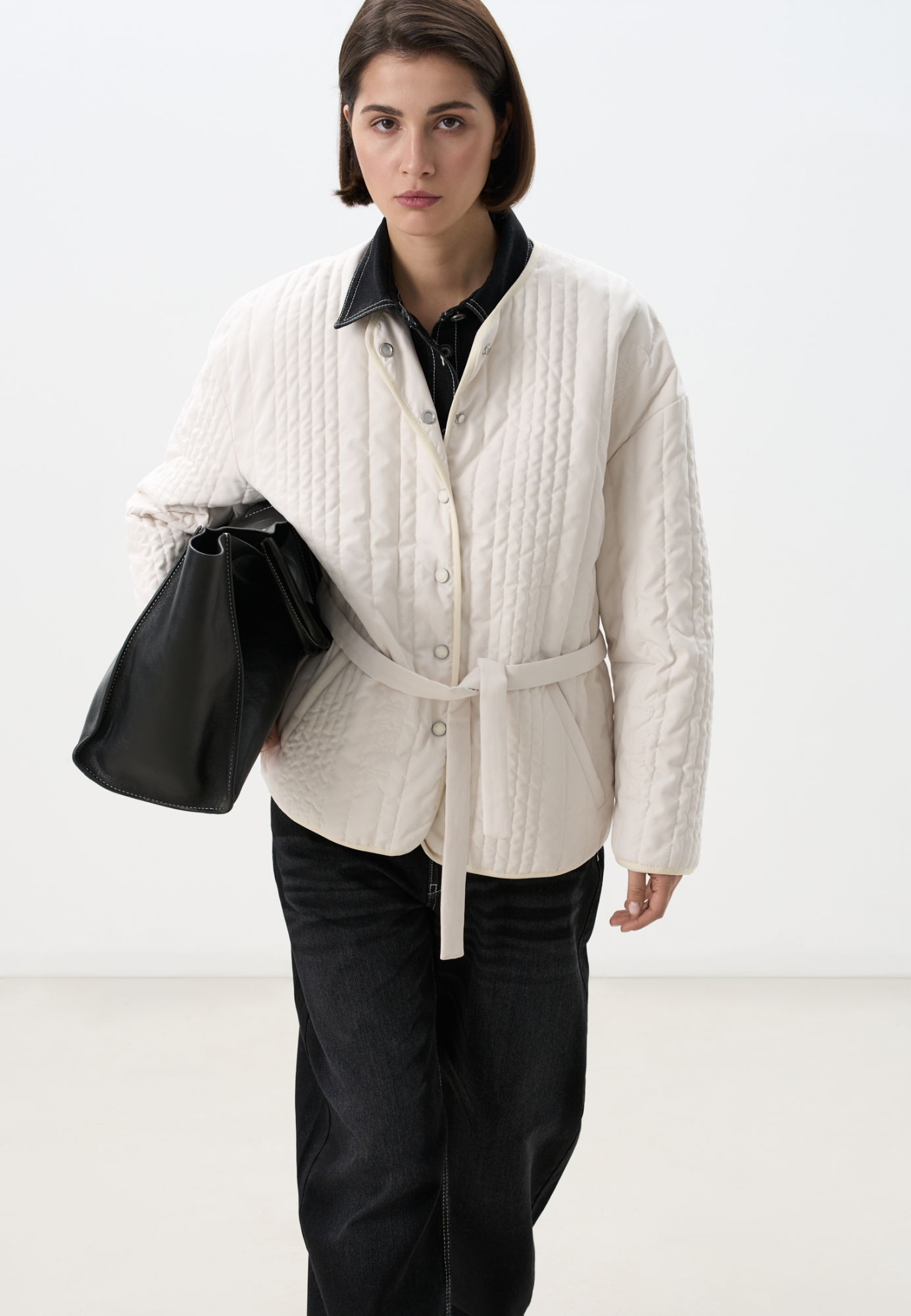 Стеганая куртка на синтепоне из нейлона. Модель с круглым вырезом горловины, спущенной линией плеч и карманами. Застежка на кнопки.<br />
Изделие можно использовать как второй слой под верхнюю одежду.