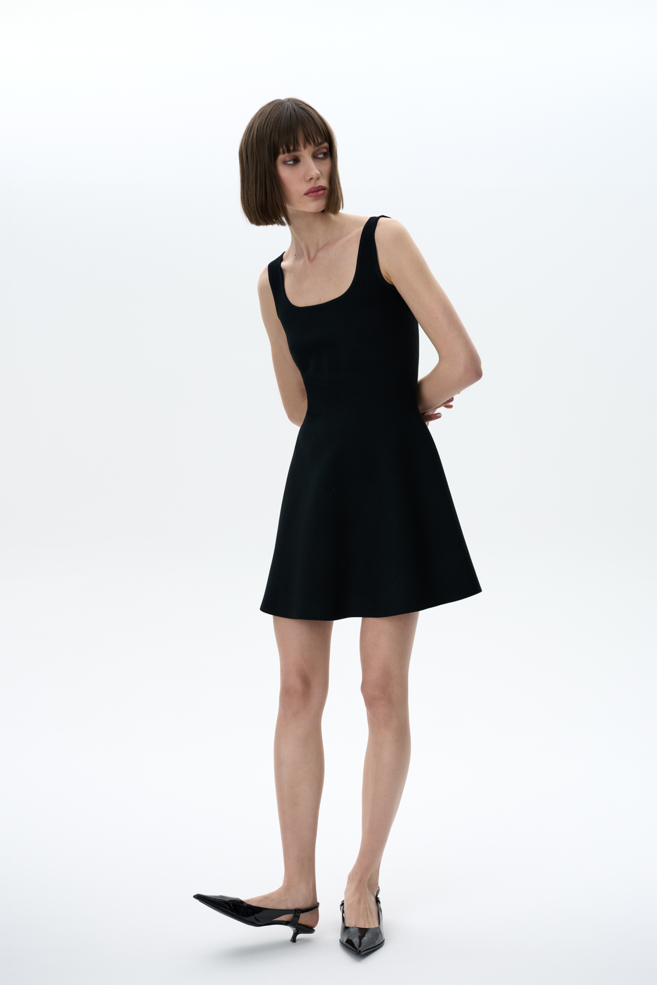 Трикотажное мини платье в стиле baby doll на широких бретелях. Круглый вырез, застежка сзади на молнию. Платье связано из плотной эластичной вискозы, что позволяет прилегать по фигуре и держать объем у юбки.