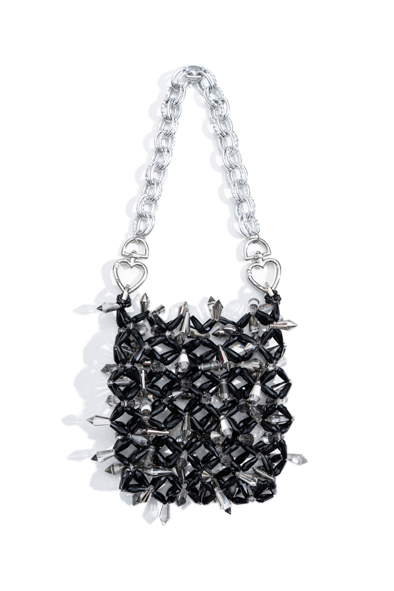Сумочка, выполненная путем переплетения бусин-кристаллов. Модель с одной короткой ручкой с карабинами-сердечками. Непрозрачный мешочек в комплекте. Высота изделия составляет 12 см, длина цепочки - 69 см.
