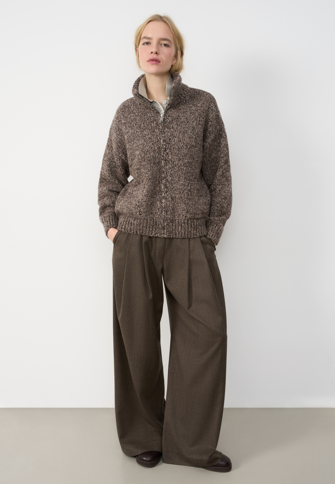 Трикотажный меланжевый бомбер из шерсти мериноса экстрафайн. Модель свободного силуэта со спущенной линией плеча, отложным воротником и двумя накладными карманами. Манжеты рукавов, низ и воротник изделия выполнены в рубчик.