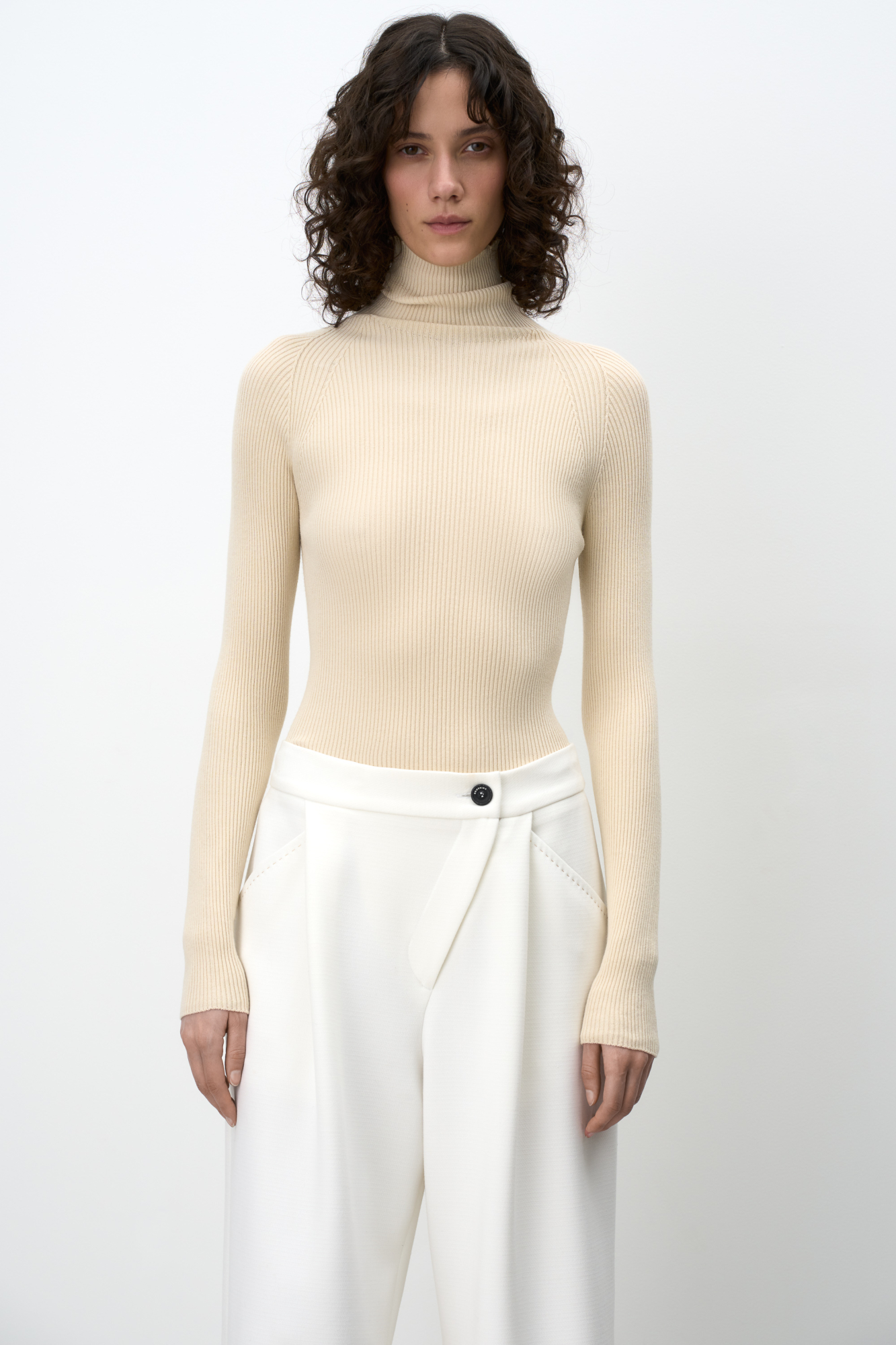 Трикотажная бесшовная водолазка из эластичной вискозы. Модель приталленого силуэта, с высоким воротником-стойкой и длинными рукавами. Изделие выполнено в рубчик.