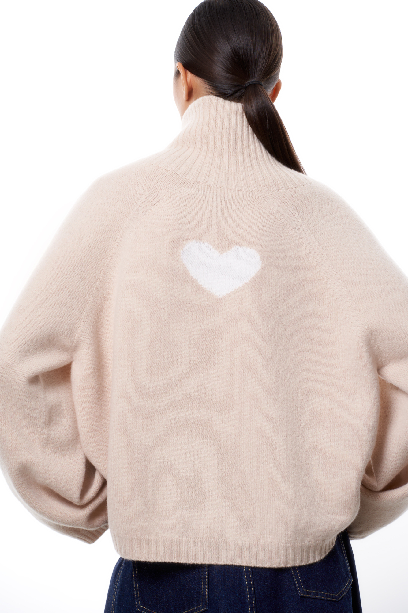 Трикотажный джемпер из шерсти с добавлением кашемира. Модель с высоким воротником в рубчик, спущенной линией плеча и жаккардовым рисунком в виде сердца на спине.