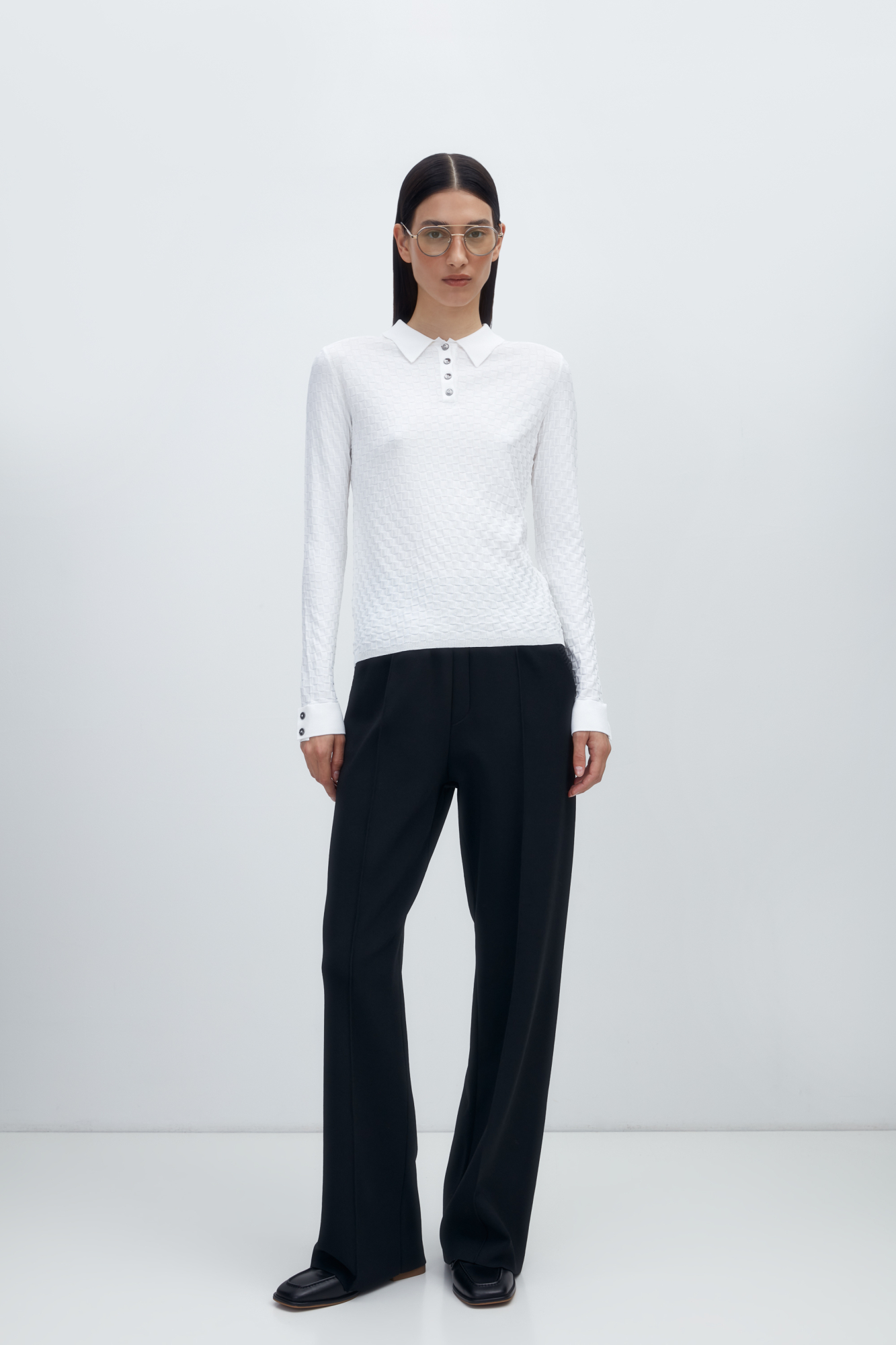 Трикотажная футболка с длинными рукавами, выполненная в клетку. Модель с воротником поло и пуговицами на планке.