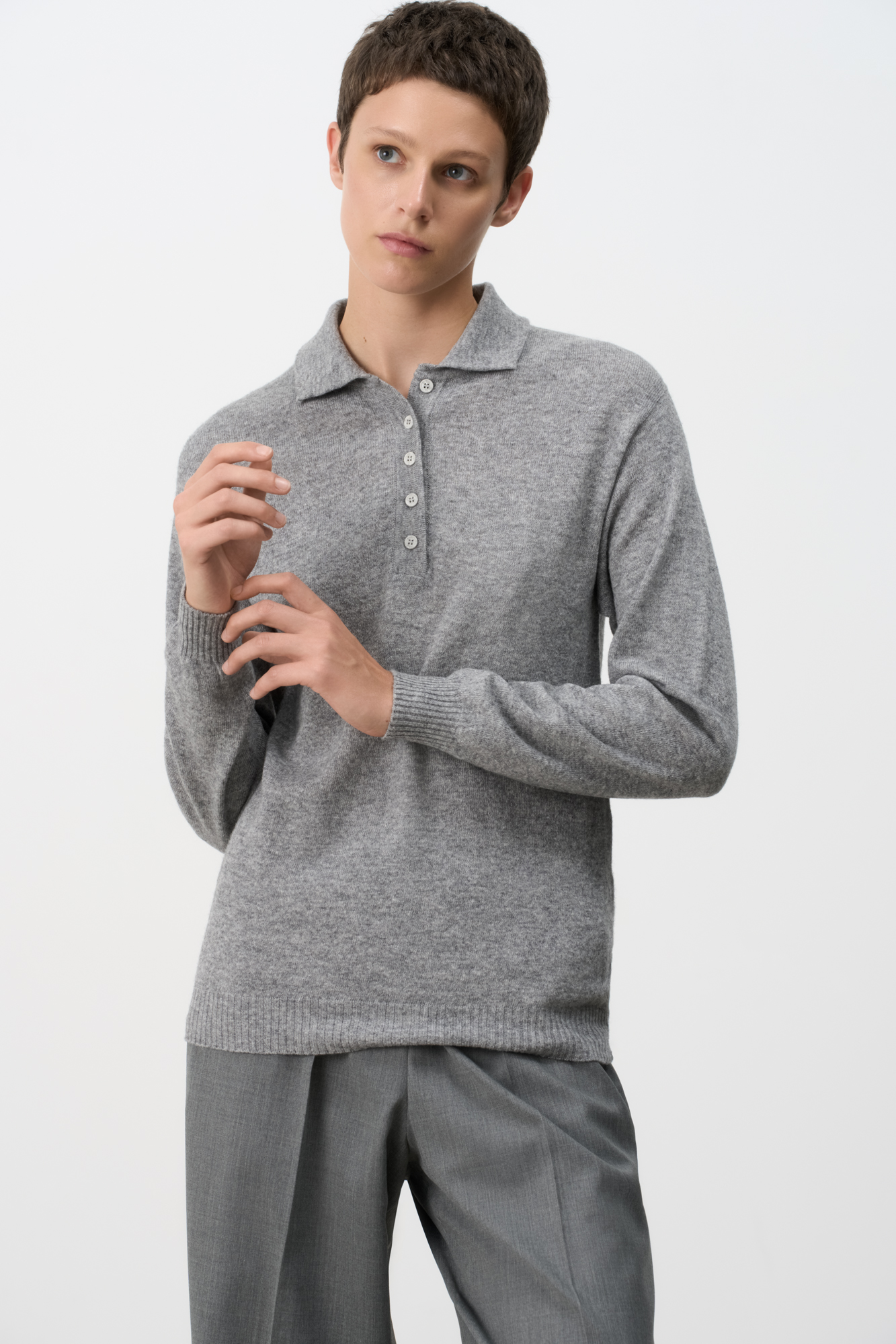 Трикотажный джемпер из кашемира и шерсти. Модель прямого силуэта со спущенной линией плеча и воротником поло на пуговицах. Манжеты рукавов и низ изделия выполнен в рубчик.