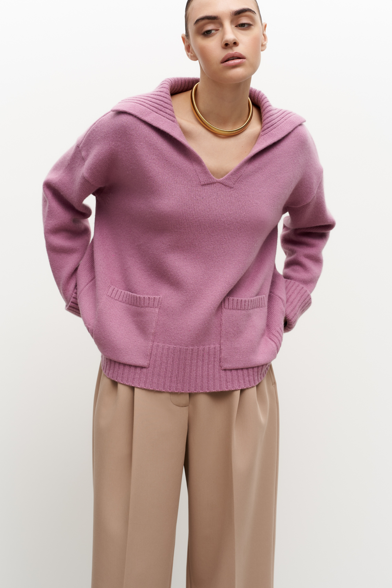 Трикотажный джемпер из шерсти с V-образным вырезом и отложным воротником. Модель свободного силуэта с накладными карманами.