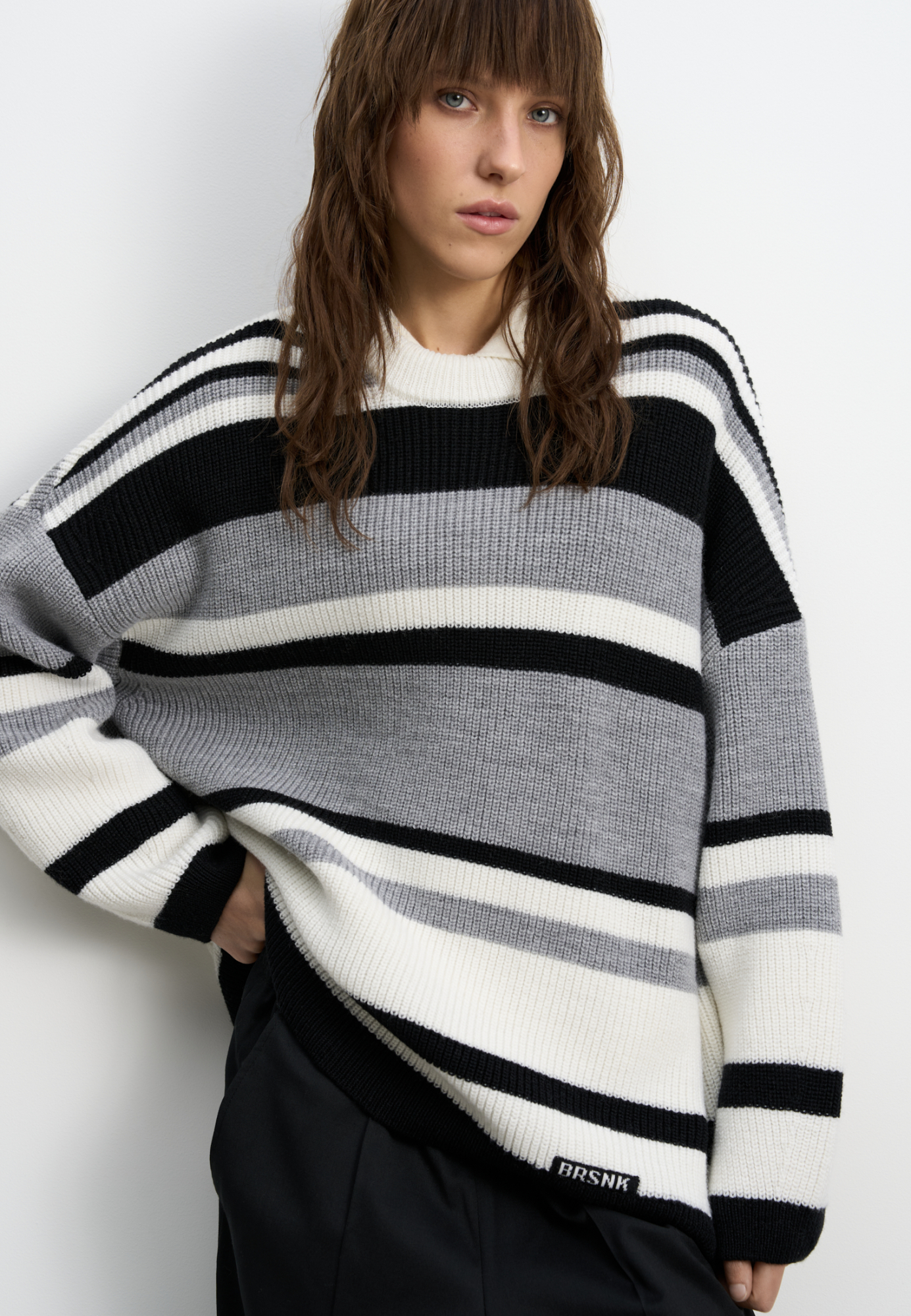 Трикотажный джемпер из шерсти в полоску. Модель свободного силуэта, со спущенной линией плеч, длинными рукавами и круглым вырезом горловины. Изделие декорировано пришивным логотипом бренда.