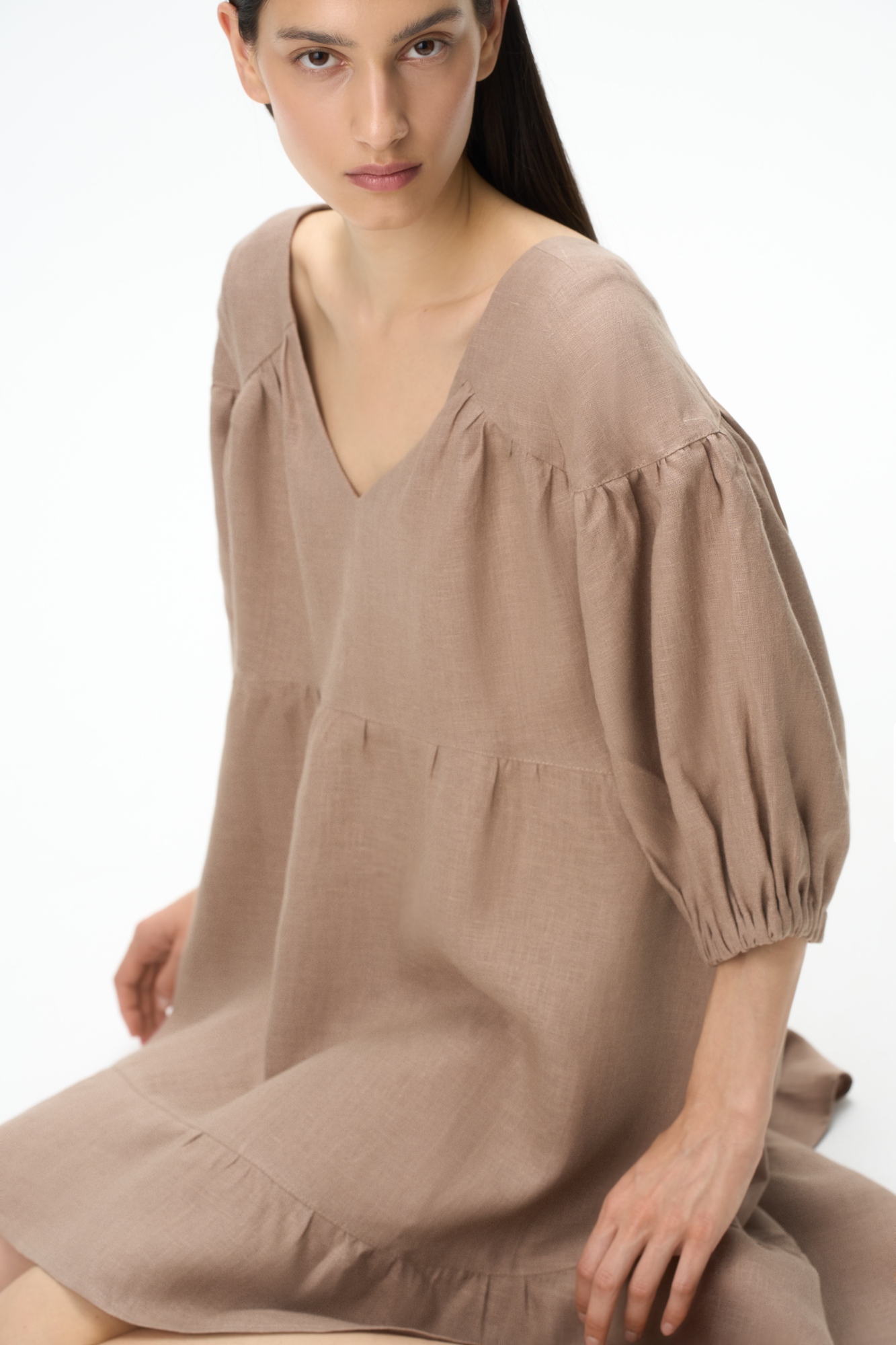 Короткое платье из 100% льна с расклешением от талии и широким асимметричным воланом внизу. Модель свободного кроя с коротким рукавом на резинке и V-образным вырезом с завязками на спине.