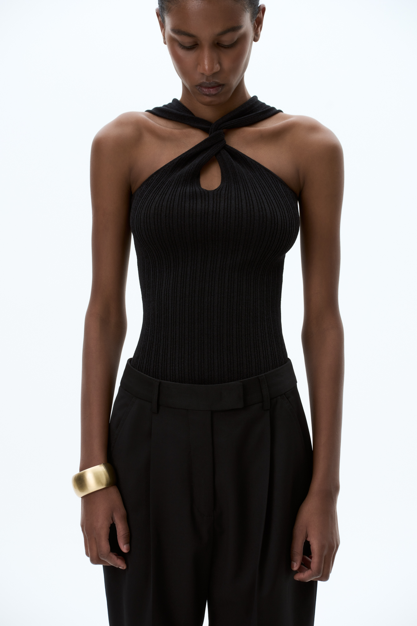 Трикотажный топ с двойным перекрутом на груди. Модель приталенного силуэта с открытыми плечами.