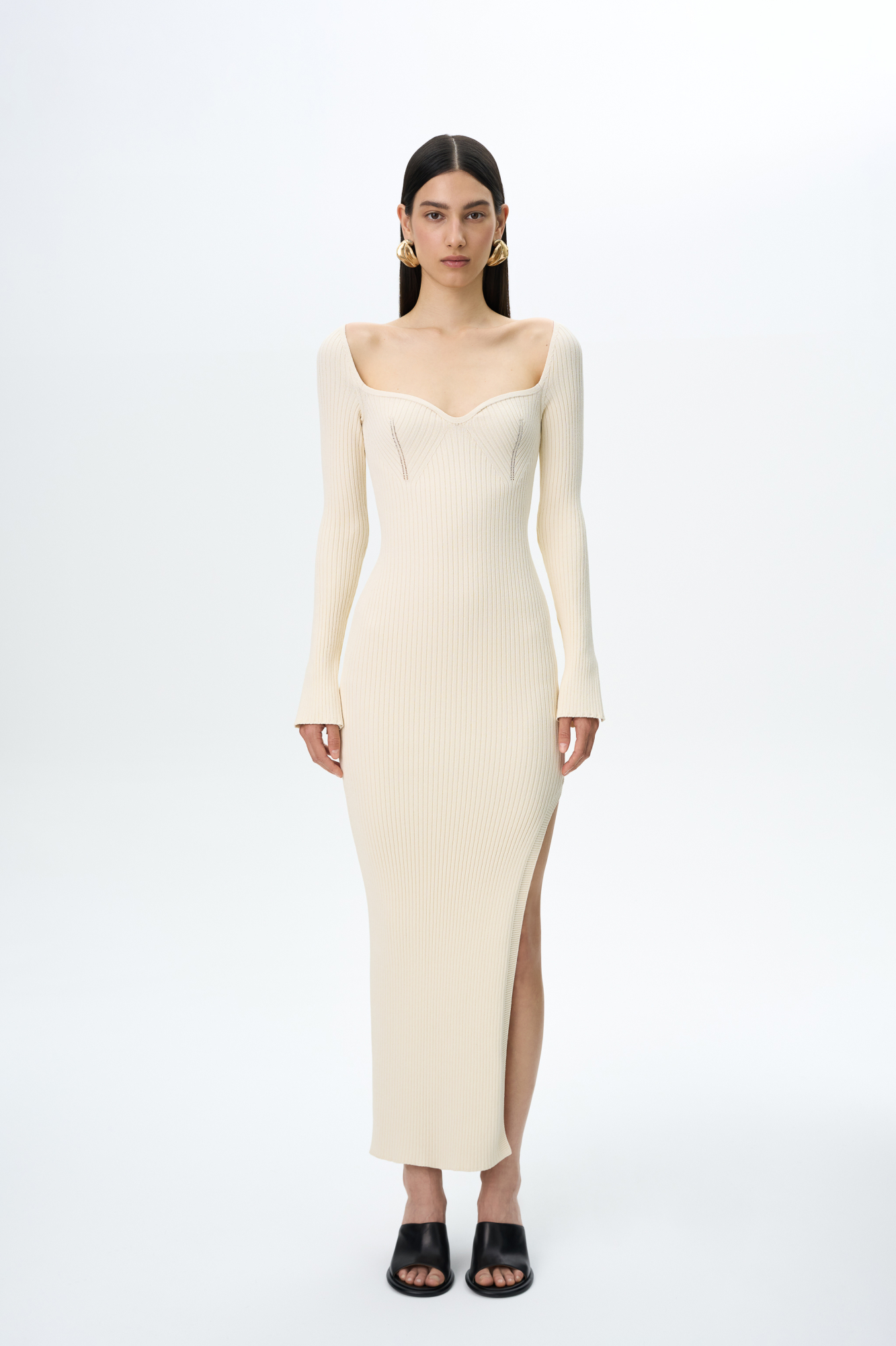 Трикотажное платье из вискозы длины миди. Модель приталенного силуэта, с длинным рукавом, глубоким вывязанным декольте с вытачками и разрезом сбоку.