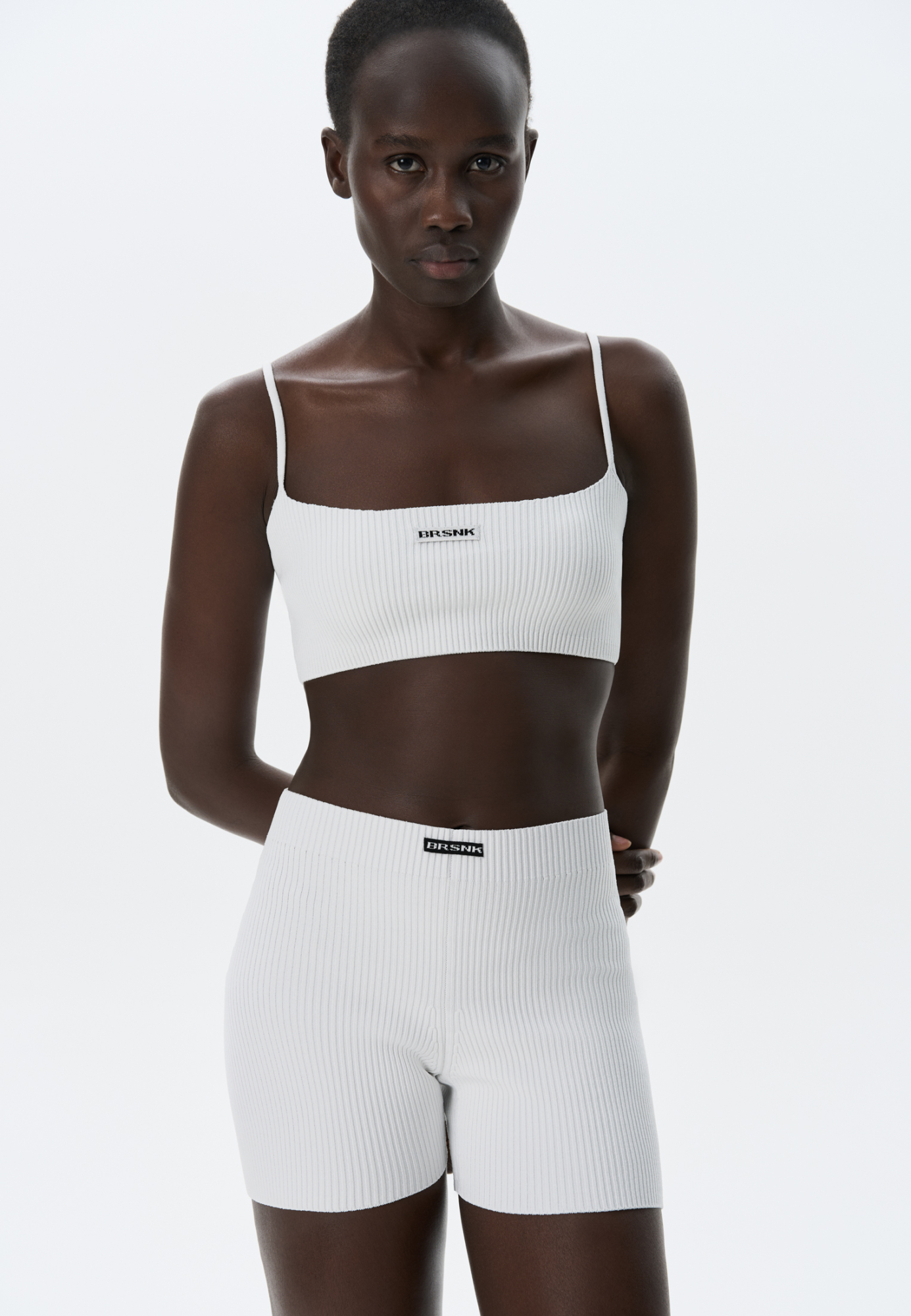 Трикотажный короткий топ из вискозы в спортивном стиле. Модель выполнена в рубчик на тонких бретельках. Брендированный жаккард на груди. Дополнить образ можно шортами в таком же стиле. 