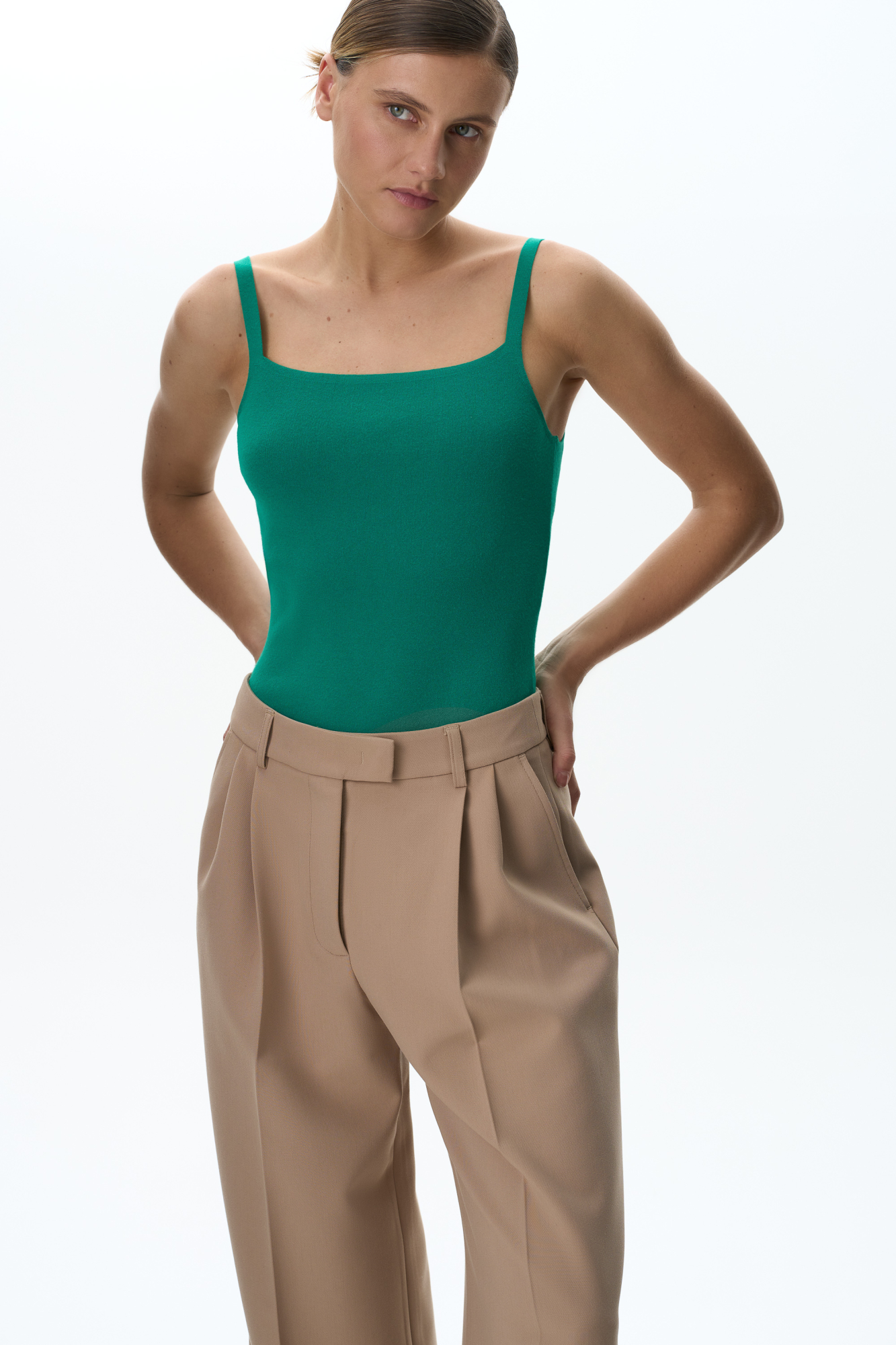 Трикотажное боди из вискозы. Модель приталенного силуэта на тонких бретелях и глубоким вырезом. Изделие застегивается на крючки.