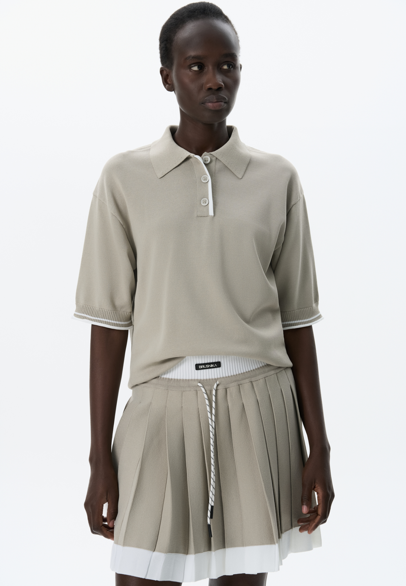 Трикотажная юбка плиссе длины мини из вискозы. Модель с широким эластичным поясом в рубчик. Пояс и нижняя часть юбки выполнены из пряжи контрастного цвета.