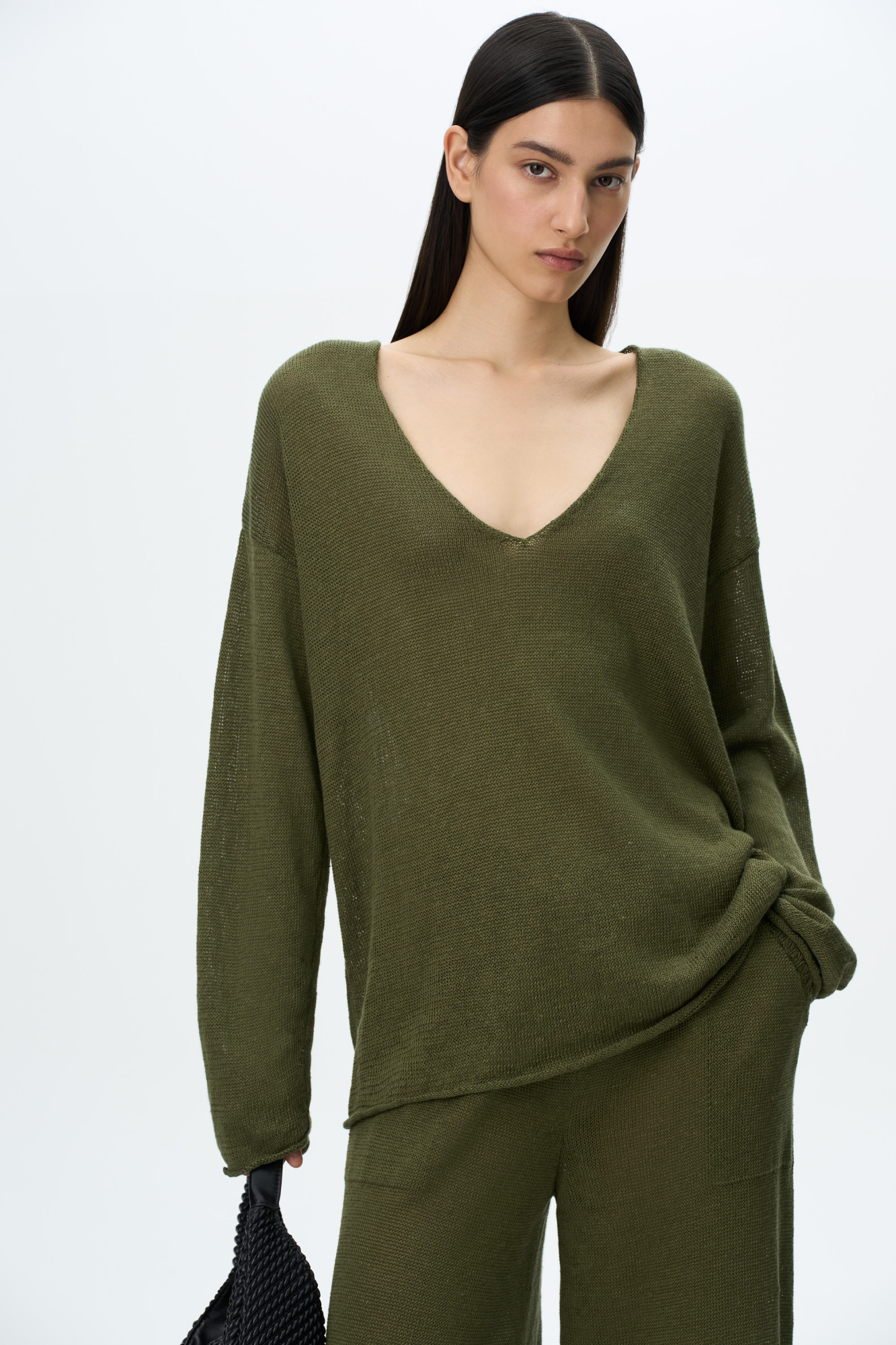 Трикотажный джемпер из 100% льна. Модель свободного силуэта с длинным рукавом и с V-образным вырезом горловины. Изделие декорировано брендированным ярлыком сбоку и валиками по низу.