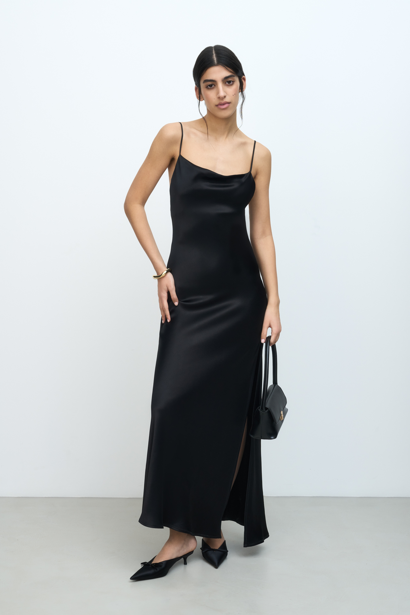 Атласное платье-комбинация длины миди из 100% вискозы. Модель приталенного силуэта, с высоким разрезом сбоку и открытой спиной,  Изделие выполнено на тонких регулируемых бретелях. 