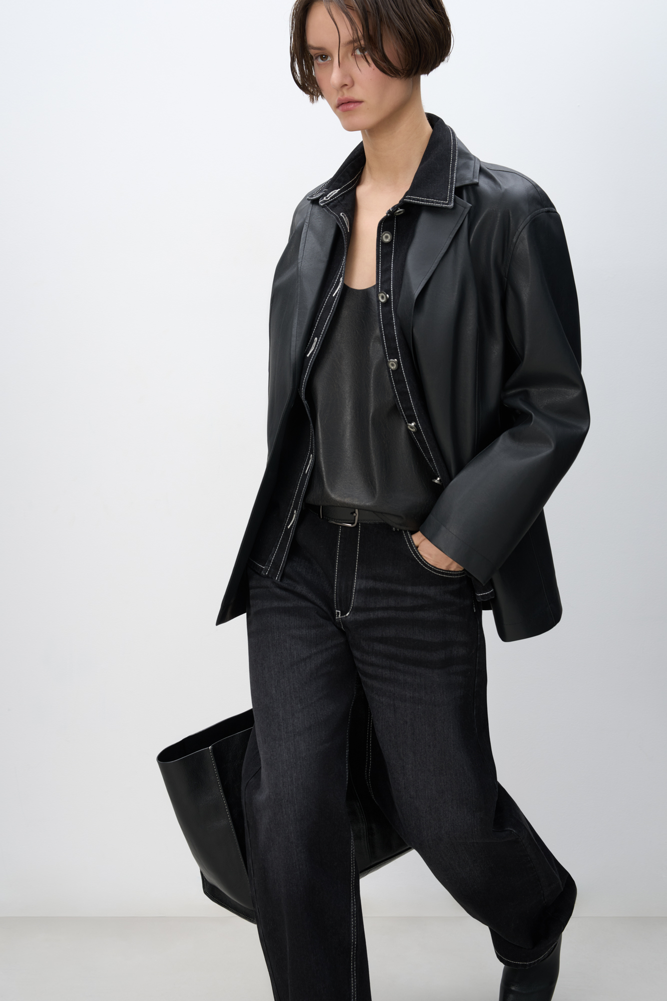 Однобортный жакет прямого кроя из пластичной двусторонней экокожи. Передние карманы с клапанами. Застежка на пуговицы.