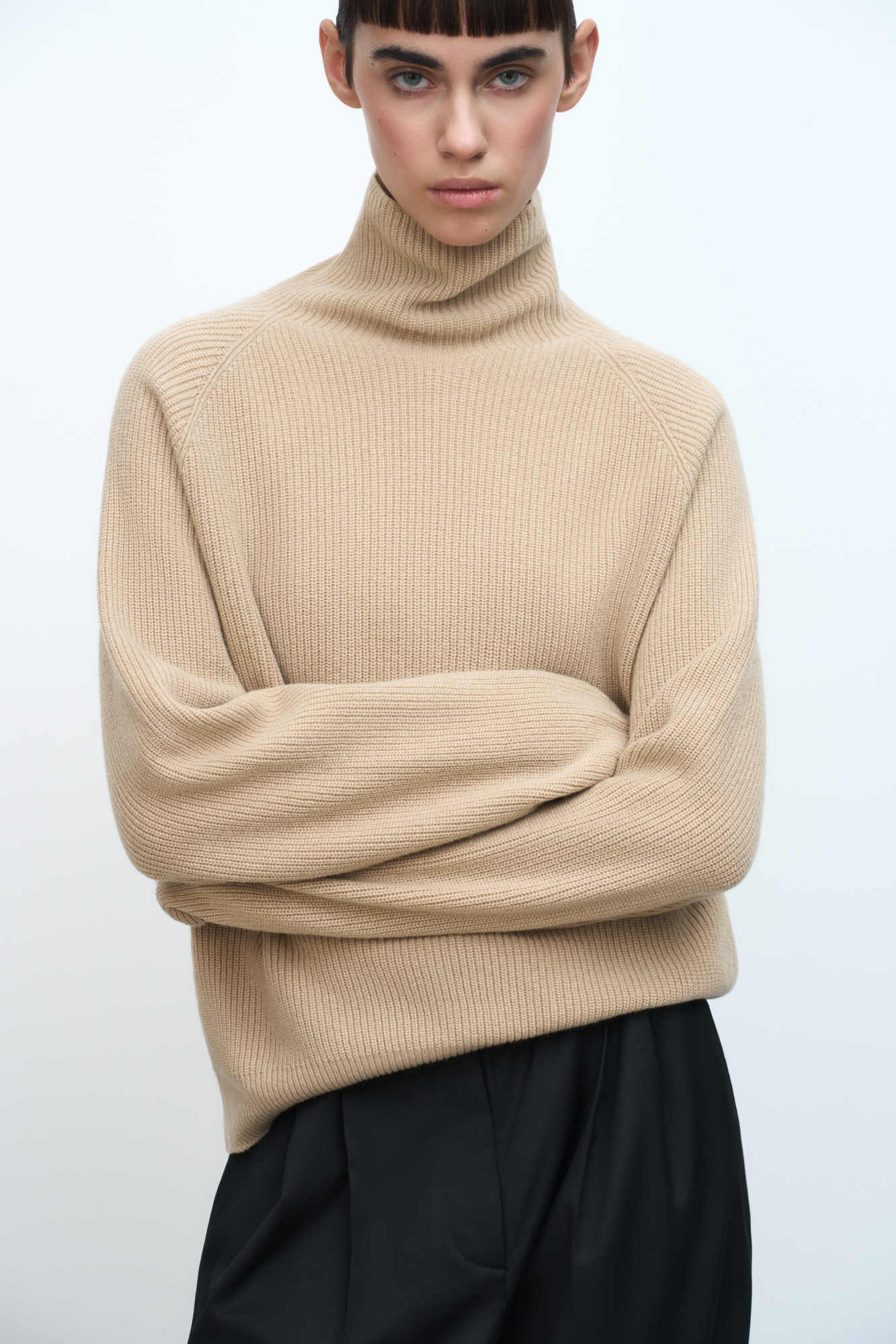 Трикотажный джемпер из шерсти и кашемира. Модель свободного силуэта с аккуратным воротником-стойкой и рукавом формы реглан. Низ изделия и манжеты рукавов выполнены на резинке.