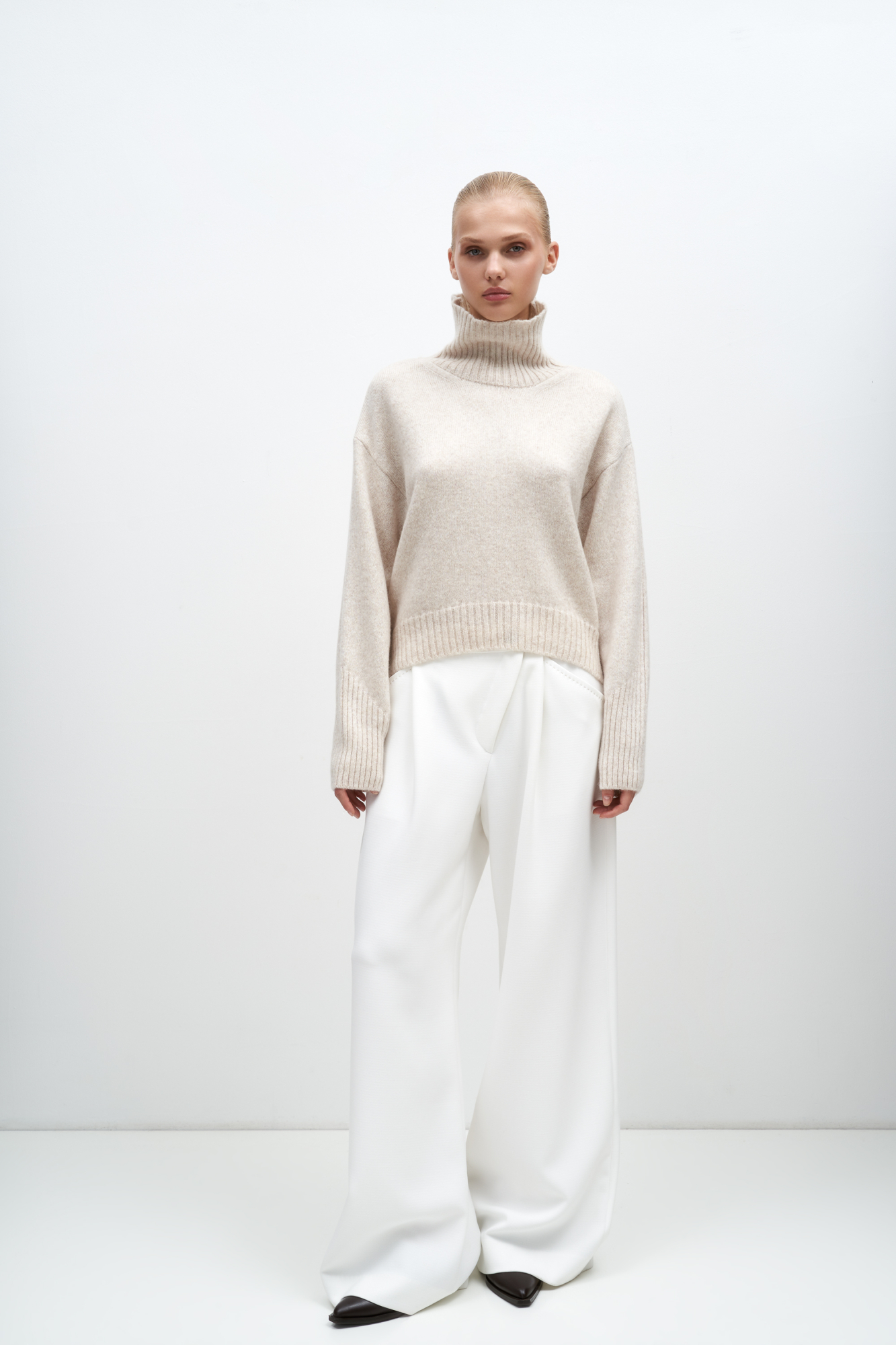 Джемпер из шерсти мериноса с высоким воротом и асимметричным низом. Рукава и низ иделия выполнены в рубчик.