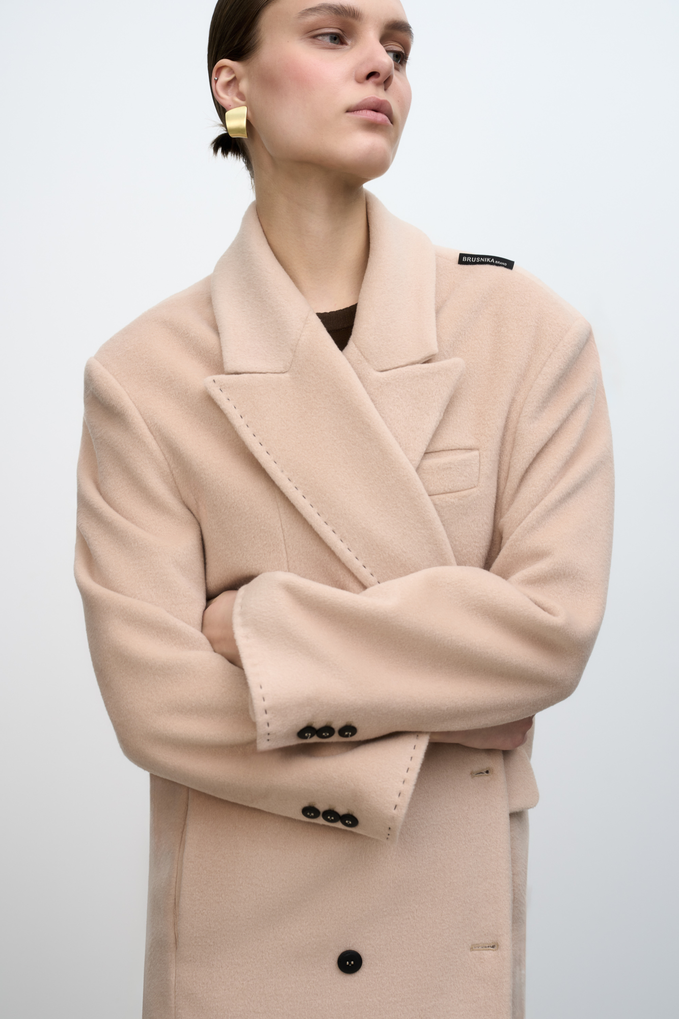 Двубортное длинное пальто из шерсти. Модель свободного силуэта с английским воротником, боковыми карманами, брендированным ярлыком сзади и застежкой на пуговицы. В комплекте пояс из экокожи. Изделие на подкладке.