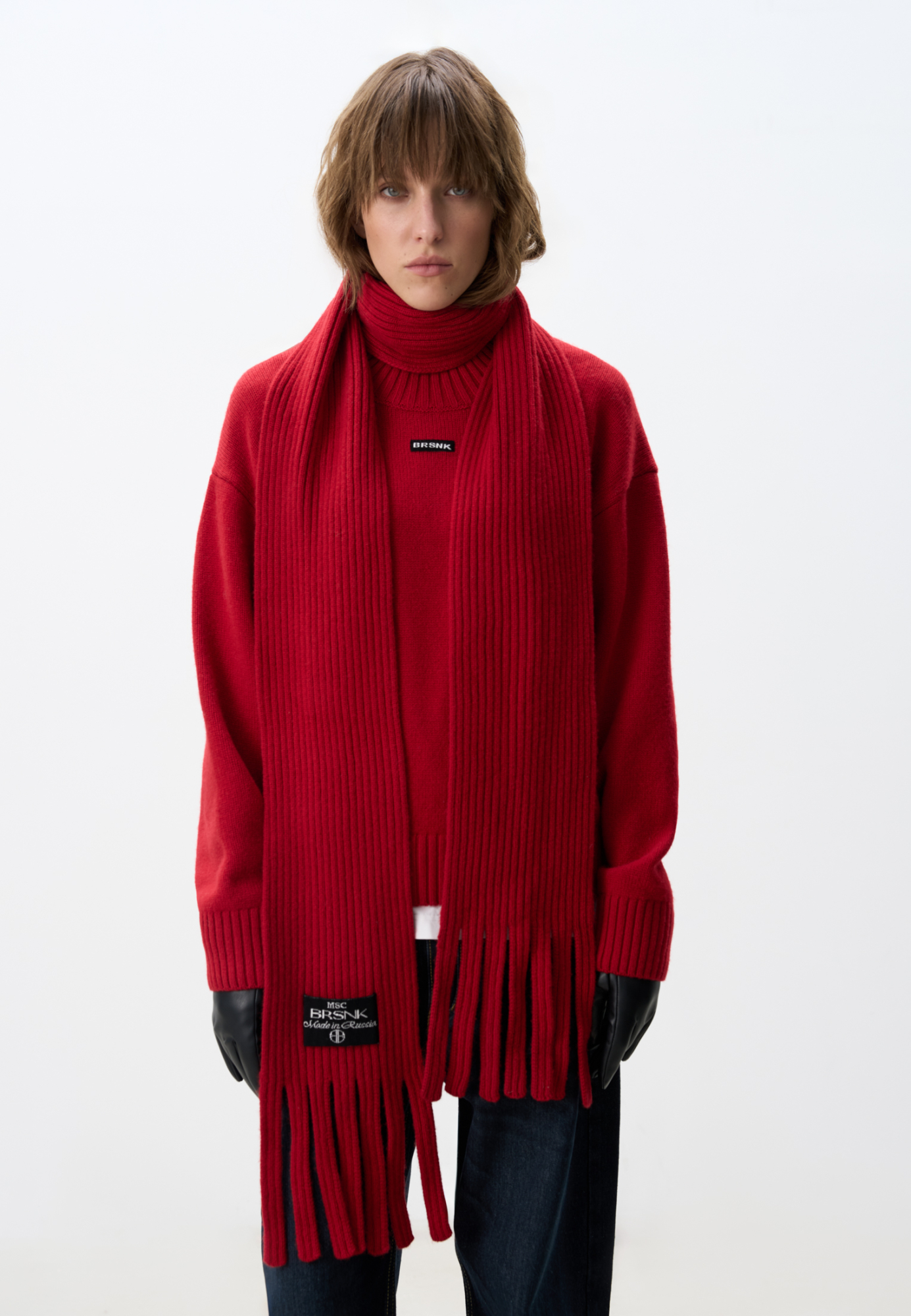 Трикотажный шарф в рубчик. Модель с бахромой и брендированным ярлыком.