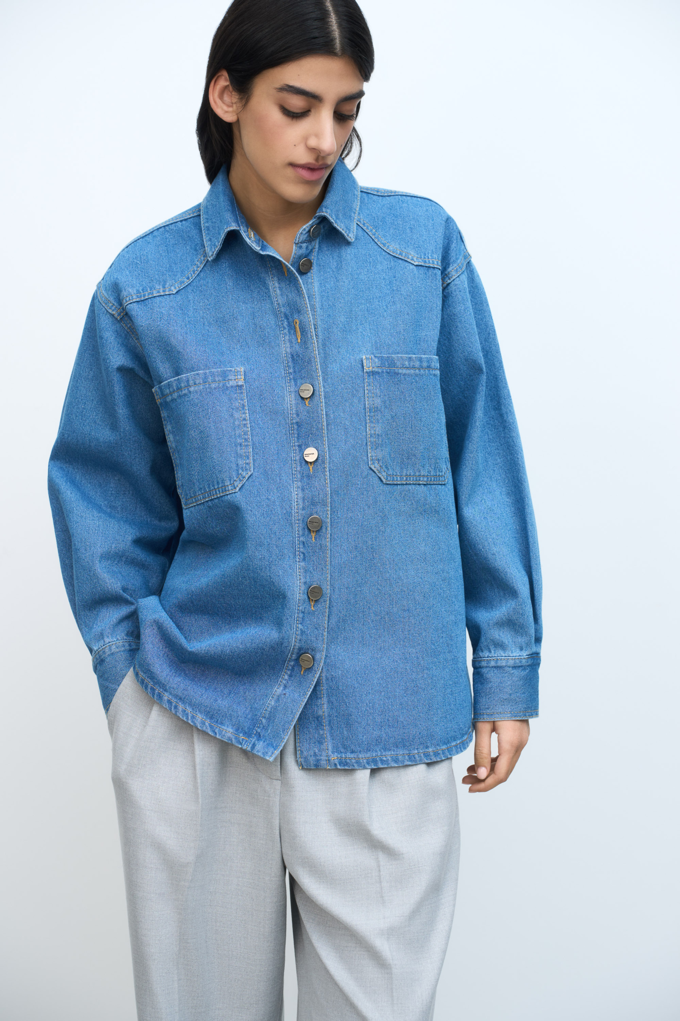 Джинсовая рубашка из 100% хлопка. Модель прямого кроя, с классическим отложным воротником, накладными карманами на груди, манжетами и застежкой на металлические пуговицы. Изделие без подкладки. 