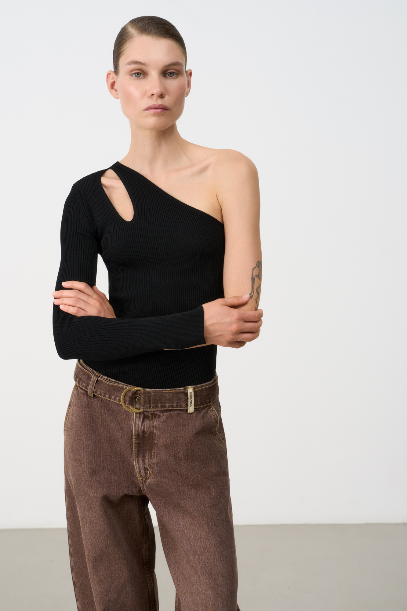 Трикотажный топ из вискозы. Модель асимметричного кроя с одним длинным рукавом и открытым плечом. Декоративный вырез на плече. Облегающий силуэт, фактурная ткань в мелкий рубчик.