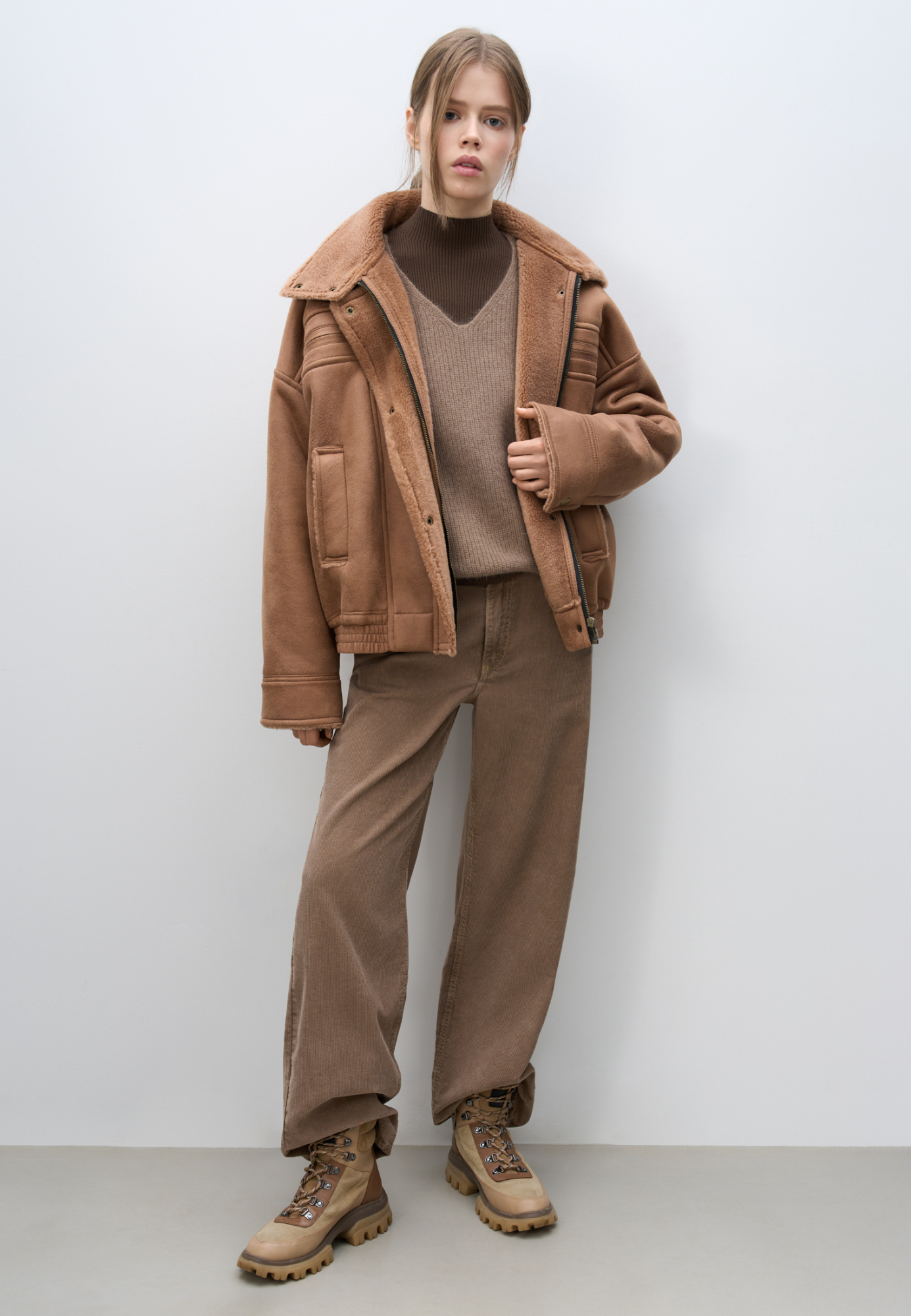 Шерстяной бомбер с воротником-стойкой. Модель свободного силуэта со спущенной линией плеча, манжетами на кнопках, нагрудными карманами на молниях и боковыми карманами. Низ изделия выполнен на резинке. Застежка на молнию под планкой с кнопками.