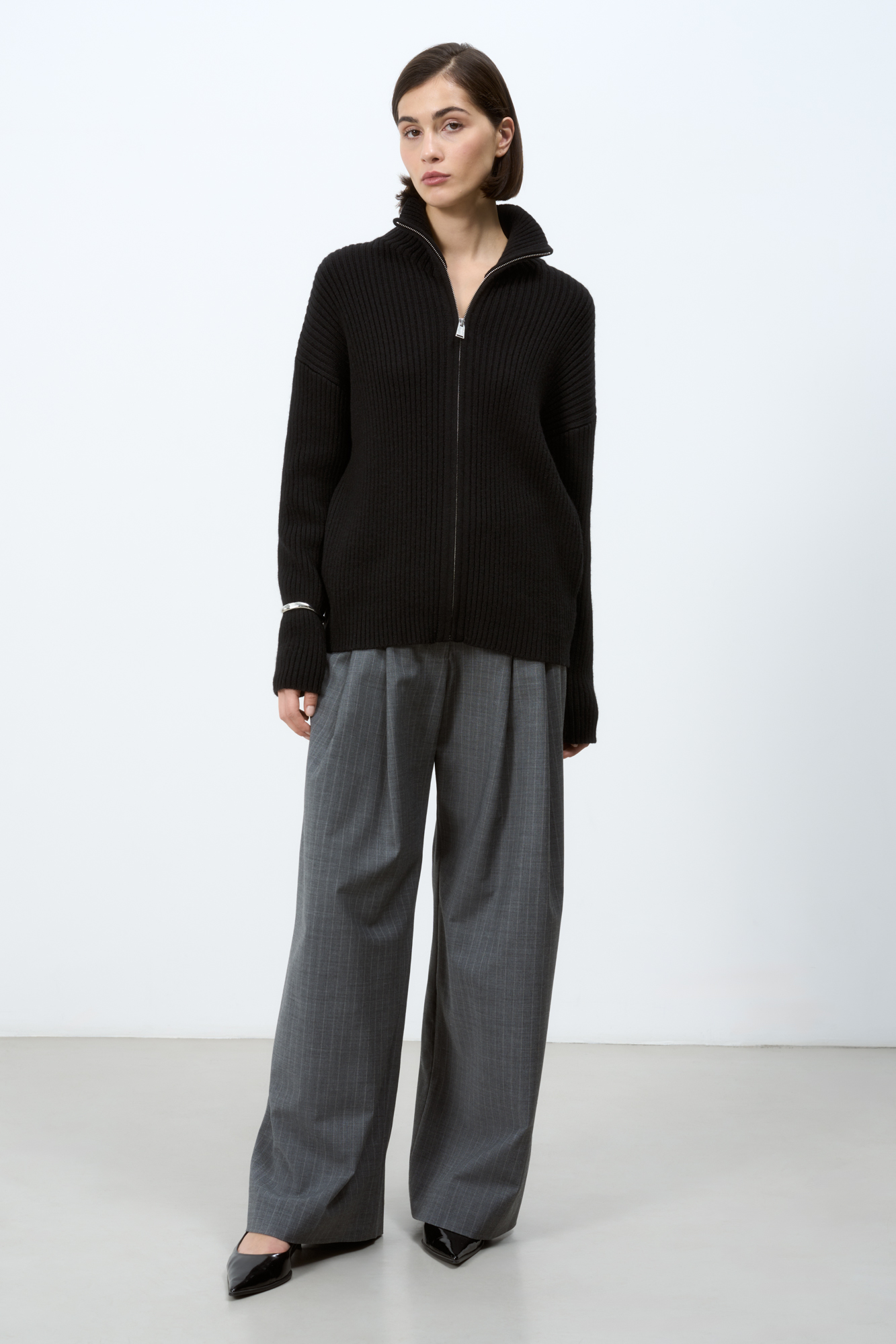 Трикотажный кардиган из смесовой шерсти с добавлением кашемира в рубчик. Модель с длинным рукавом и воротником-стойкой. Застежка на молнию.