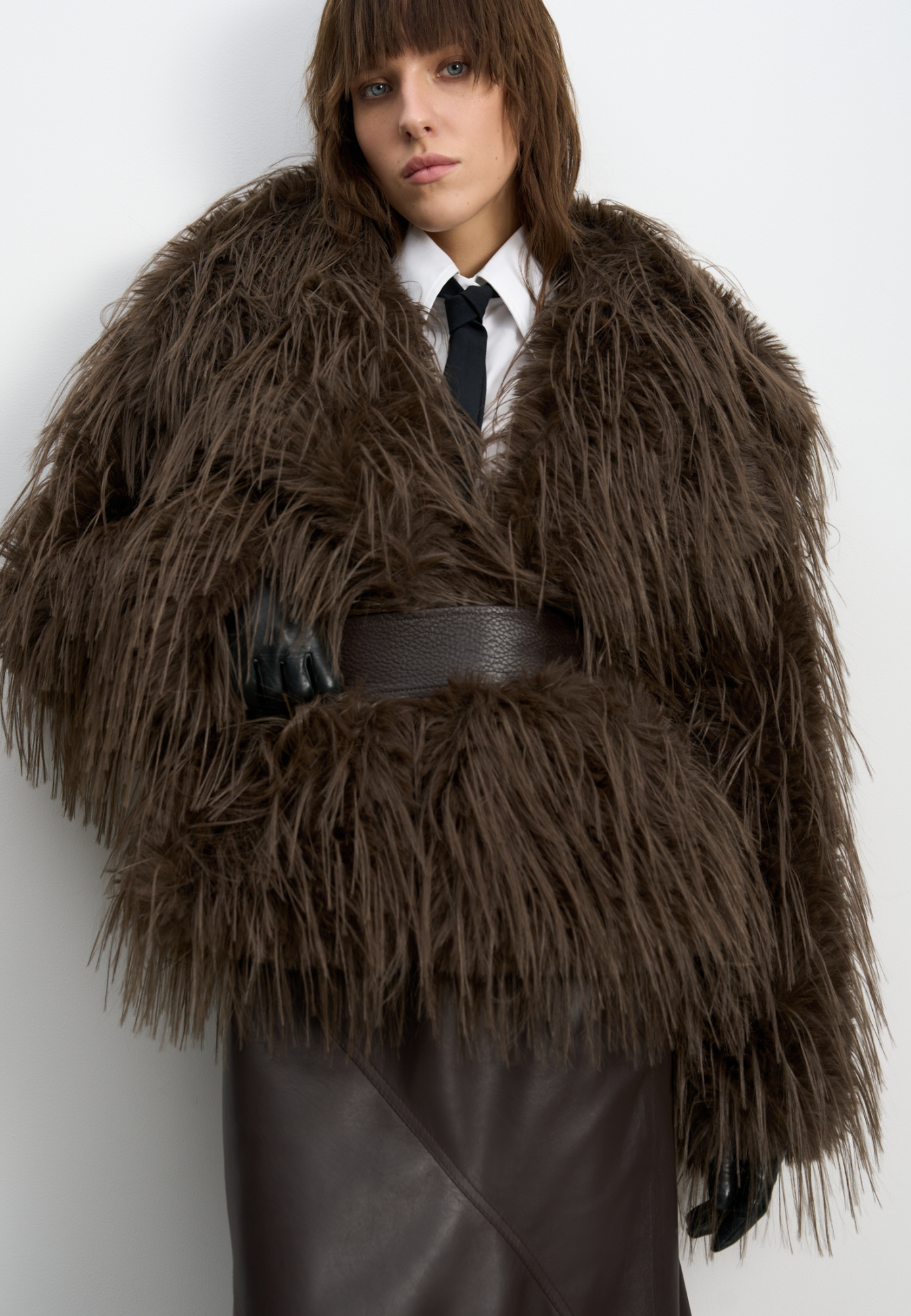 Шуба из экомеха с длинным ворсом. Модель с широким отложным воротником, шлевками для пояса из экокожи и врезными карманами. Изделие выполнено на подкладке.