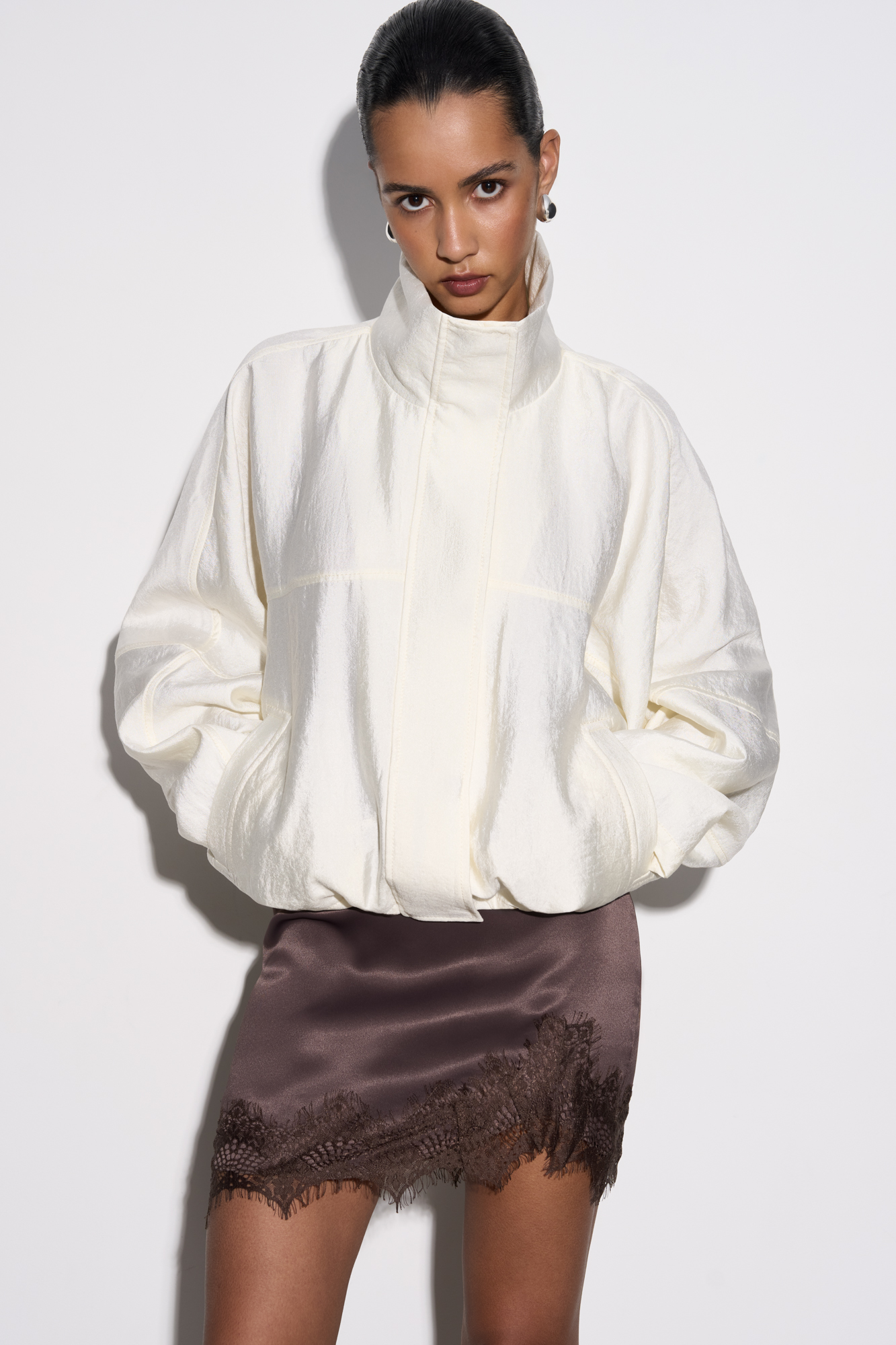 Бомбер из вискозы с воротником-стойкой. Модель свободного силуэта со спущенной линией плеча и боковыми карманами. Низ изделия выполнен на резинке. Застежка на молнию под планкой с кнопками.