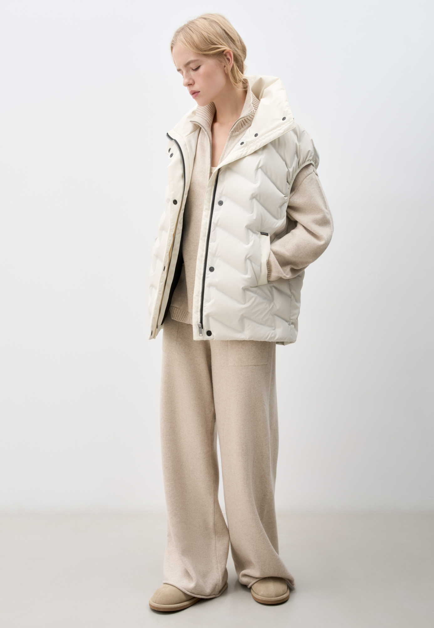 Объемный стеганый жилет на пуху. Модель прямого кроя, с воротником стойкой и боковыми карманами. Застежка на молнию и кнопки под планкой.