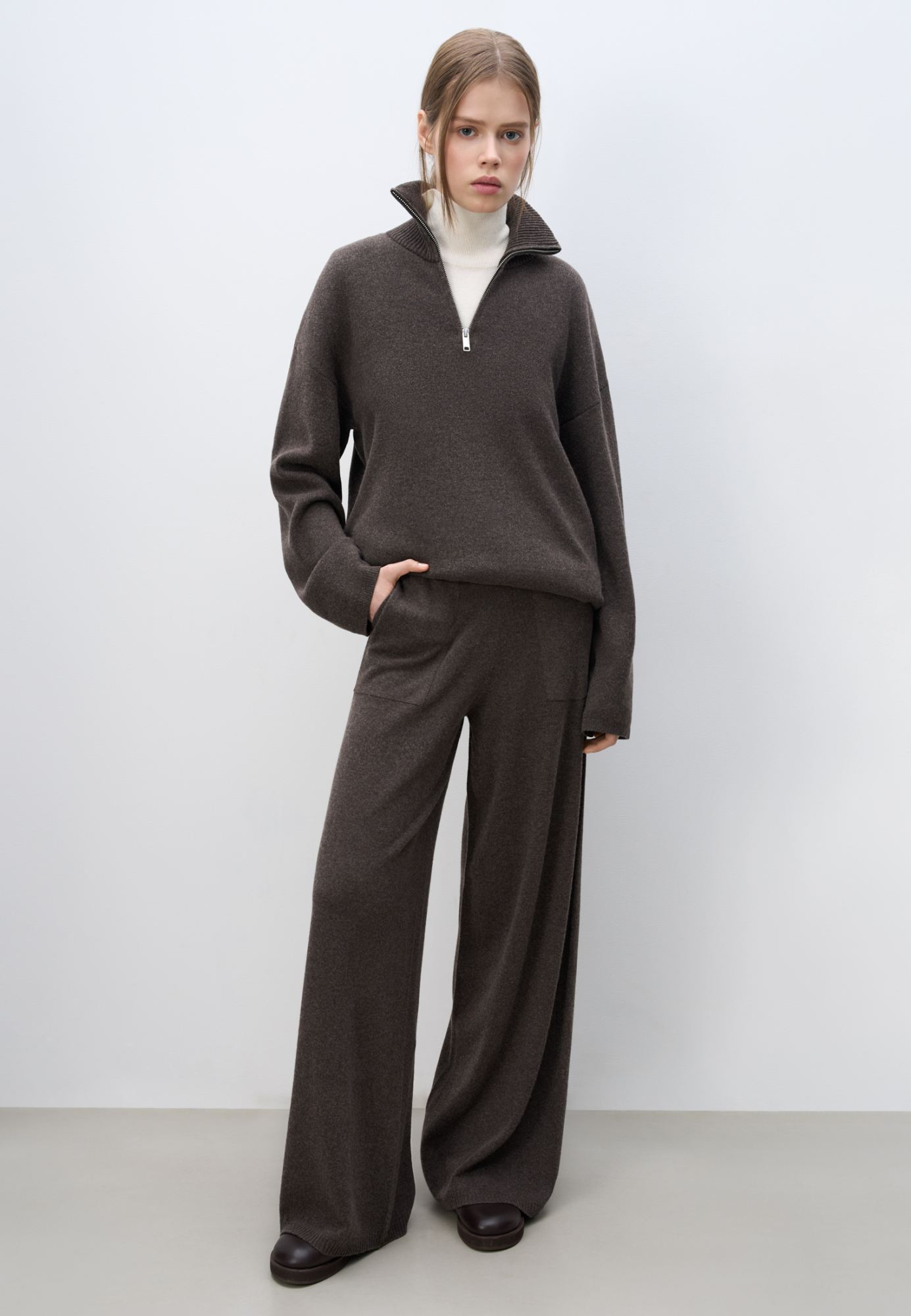 Трикотажные брюки из шерсти с добавлением кашемира. Модель свободного силуэта с эластичным поясом на кулиске и боковыми карманами. Манжеты брюк выполнены в рубчик. 