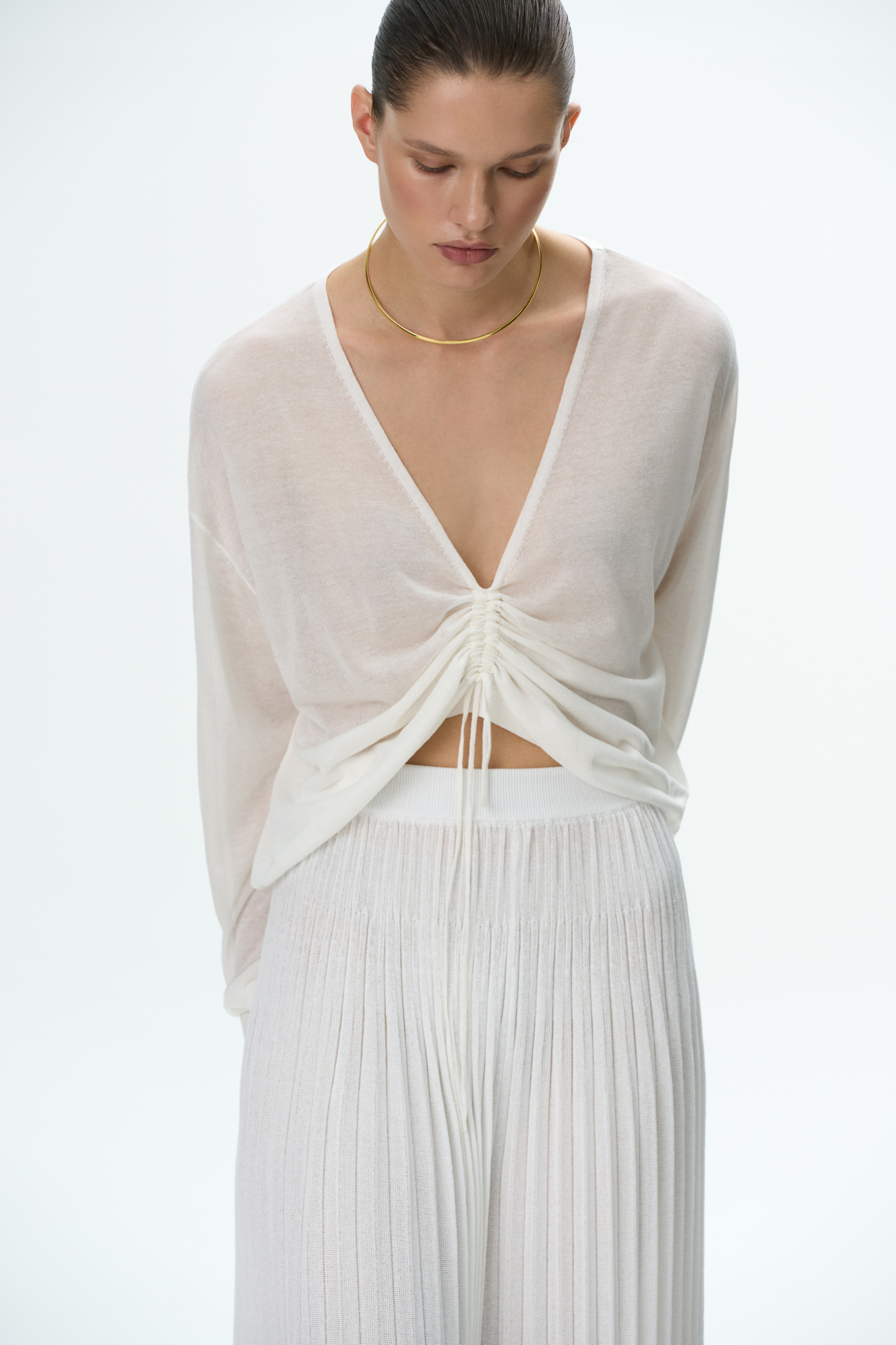 Полупрозрачный топ из тонкой вискозы. Модель свободного силуэта, с длинными рукавами и V-вырезом на кулиске.