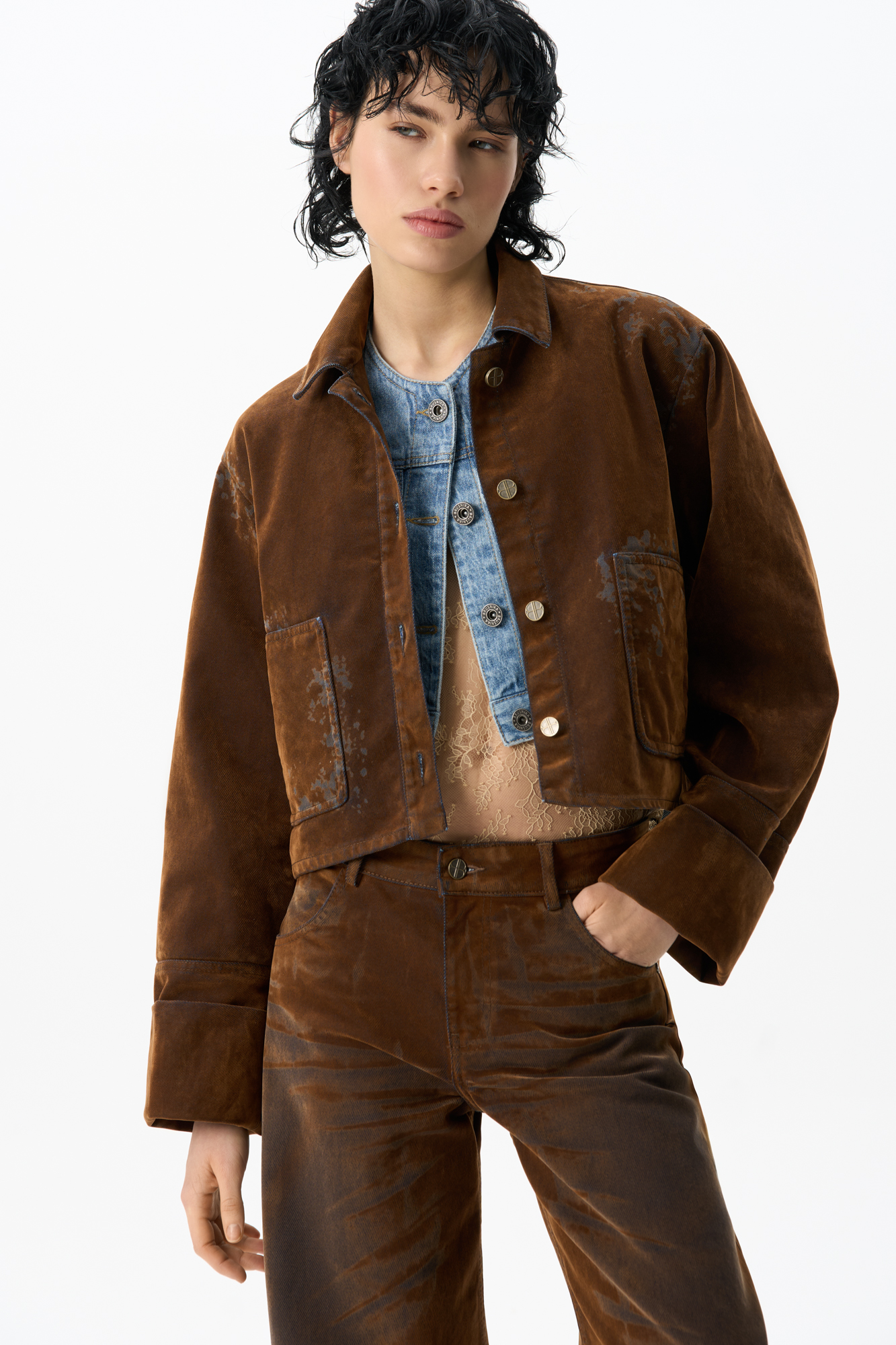 Укороченный жакет из флокированного денима - хлопка с имитацией бархатной текстуры. Модель прямого кроя с отложным воротником, накладными карманами и декоративными потертостями. Застежка на металлические брендированные пуговицы.