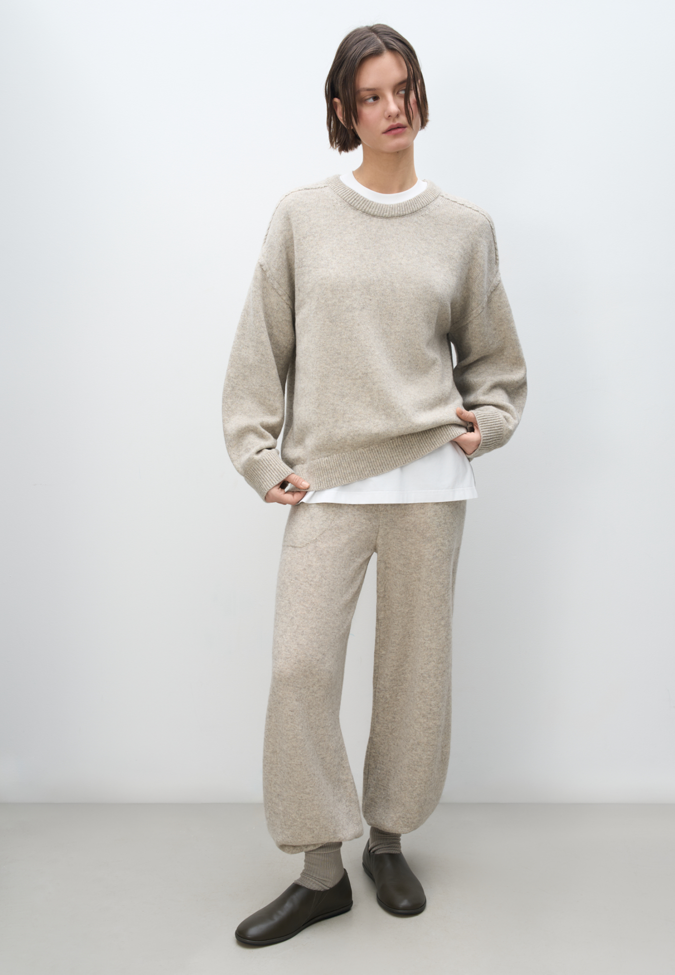 Трикотажные брюки из шерсти яка и мериноса экстрафайн. Модель с эластичным поясом на кулиске и округлыми карманами. Манжеты брюк и пояс выполнены в рубчик.