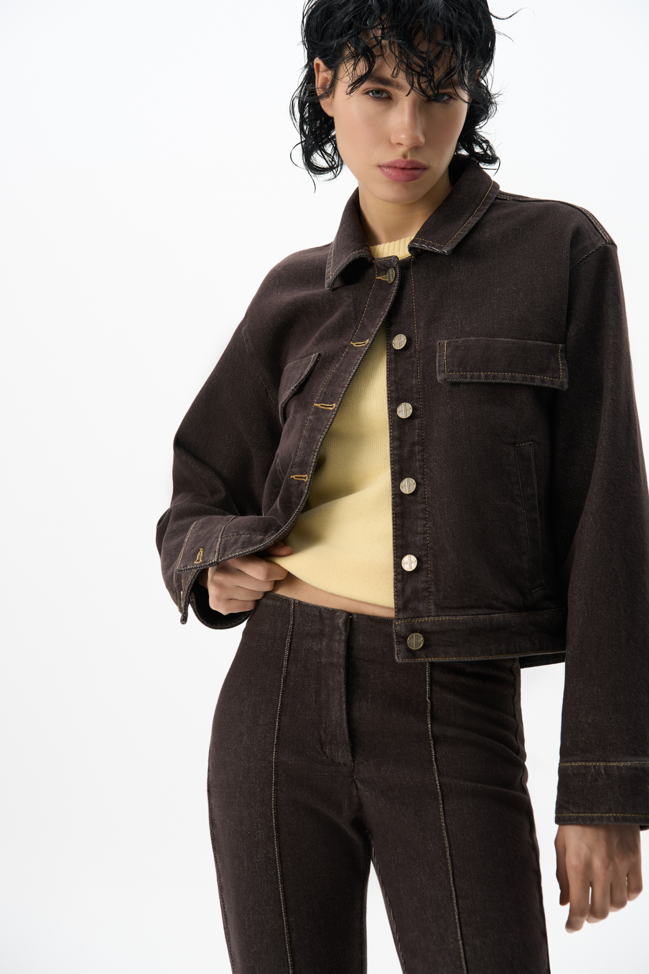 Джинсовый короткий жакет из хлопка. Модель прямого кроя с длинными рукавами на манжетах, классическим отложным воротником и карманами. Застежка на металлические брендированные пуговицы.