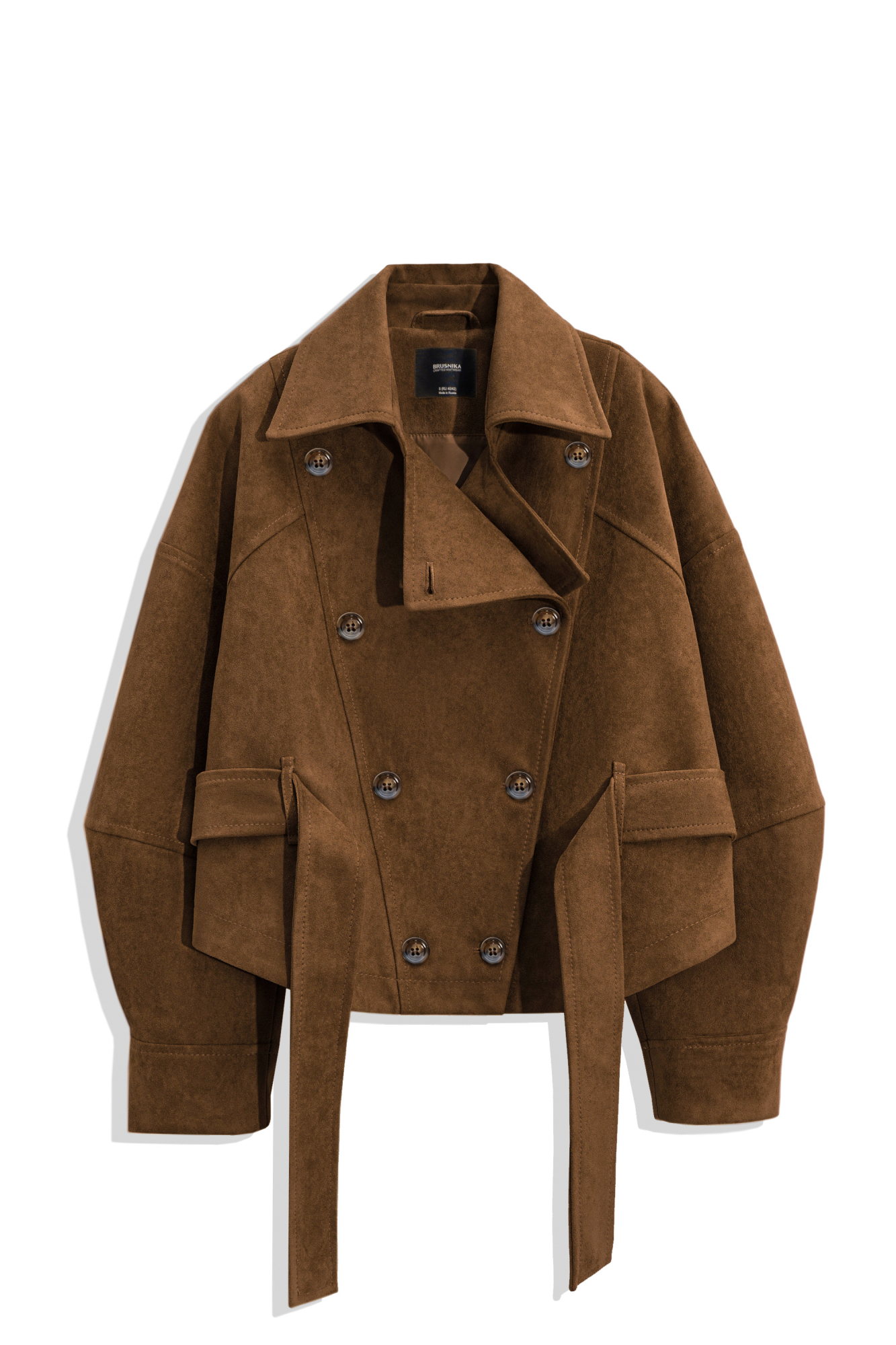 Двубортный короткий тренч сложной геометрии, выполненный из ткани с имитацией внешнего вида и свойств натуральной замши. Модель с отложным воротником, свободными рукавами со спущенной линией плеч, шлевками на поясе и ремнем.