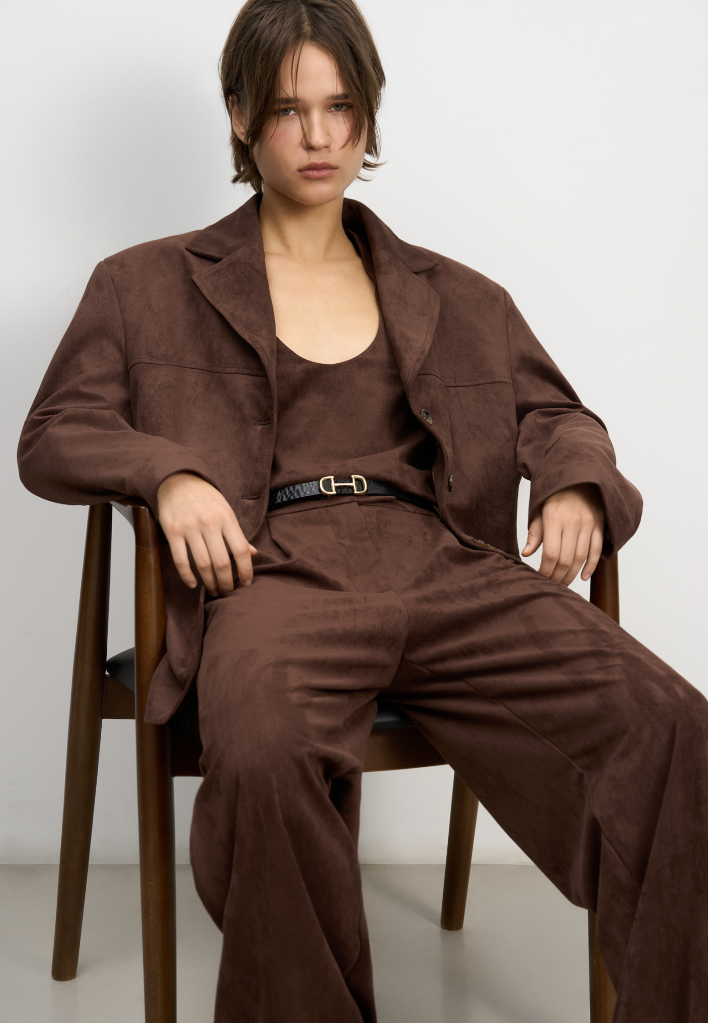 Брюки из ткани с имитацией внешнего вида и свойств натуральной замши. Модель с защипами на талии, шлевками на поясе для ремня. Застежка на скрытую пуговицу и брючный крючок. Отделка строчкой в тон.  