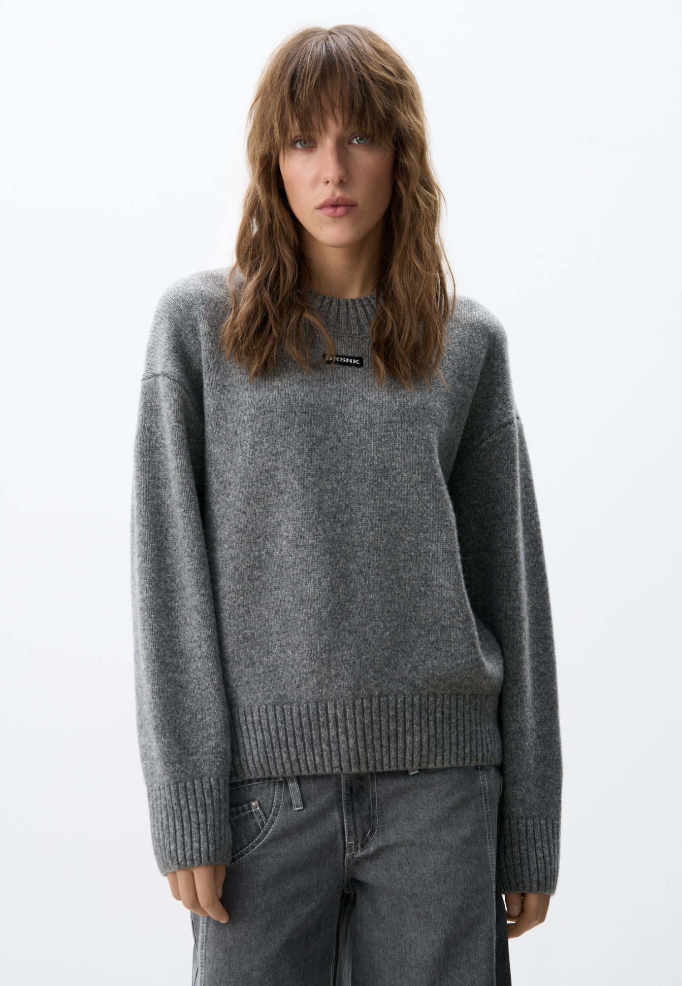 Объемный джемпер из шерсти с добавлением кашемира. Модель свободного силуэта, со спущенной линией плеч. Воротник выполен изнаночными петлями в широкий рубчик. Манжеты рукавов и низ изделия - на резинке. Джемпер декорирован брендированным трикотажным ярлычком.