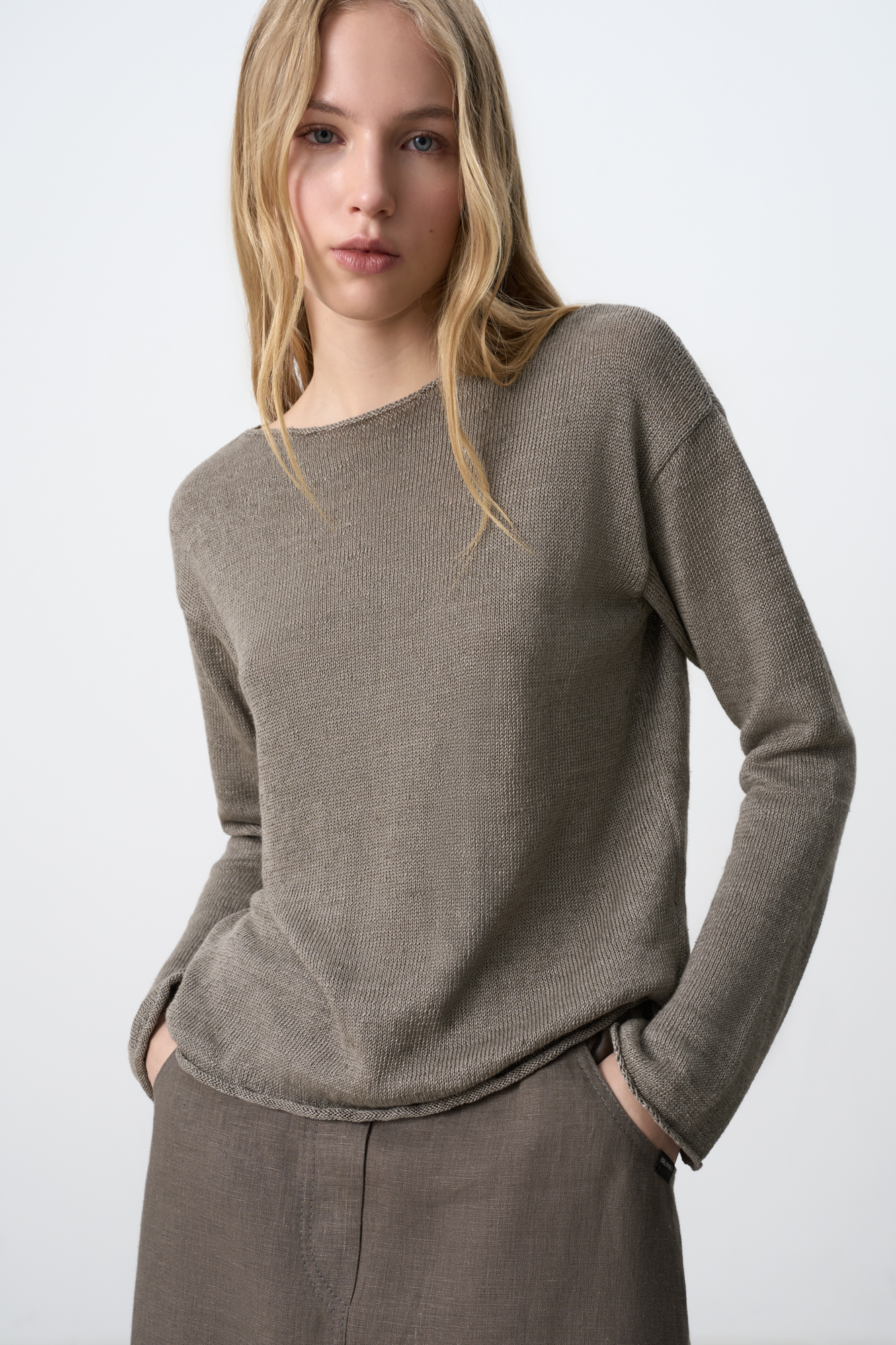 Трикотажный джемпер из 100% льна. Модель свободного кроя, со спущенной линий плеч и неглубоким вырезом горловины. Края изделия декорированы валиками. 