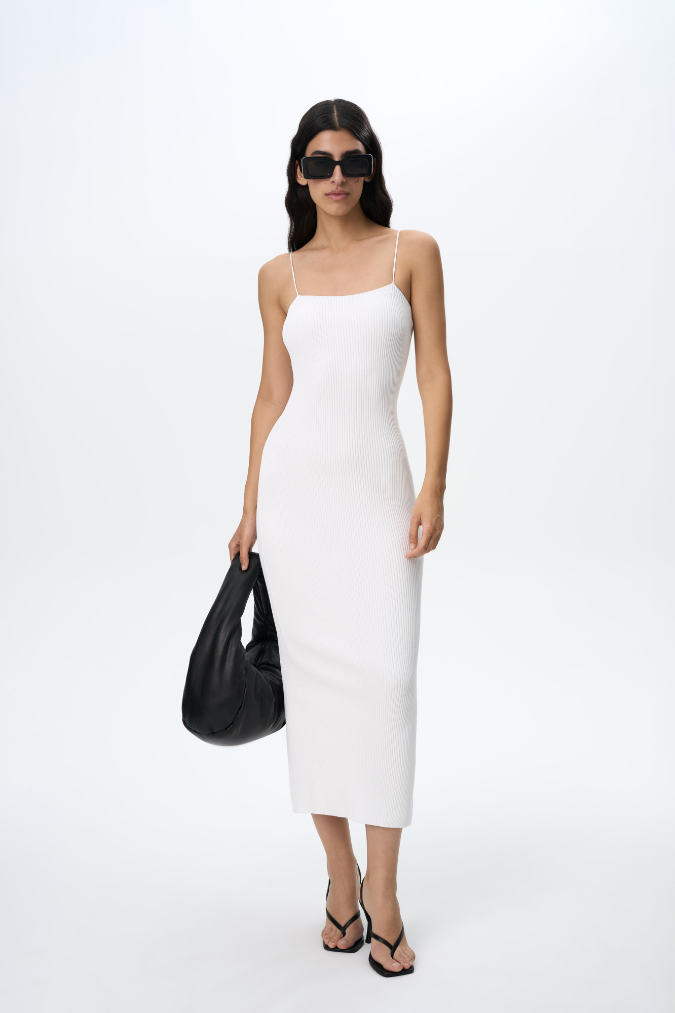 Трикотажное платье длины миди из вискозы в рубчик. Модель приталенного силуэта, на тонких бретельках и разрезом сзади.