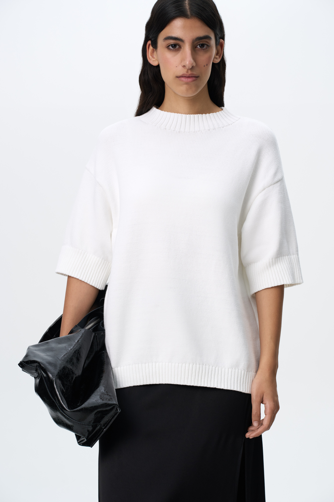 Трикотажная футболка из хлопка. Модель свободного силуэта со спущенной линией плеча, коротким рукавом и круглым вырезом горловины. Воротник, манжеты рукавов и низ изделия выполнены в широкий рубчик.